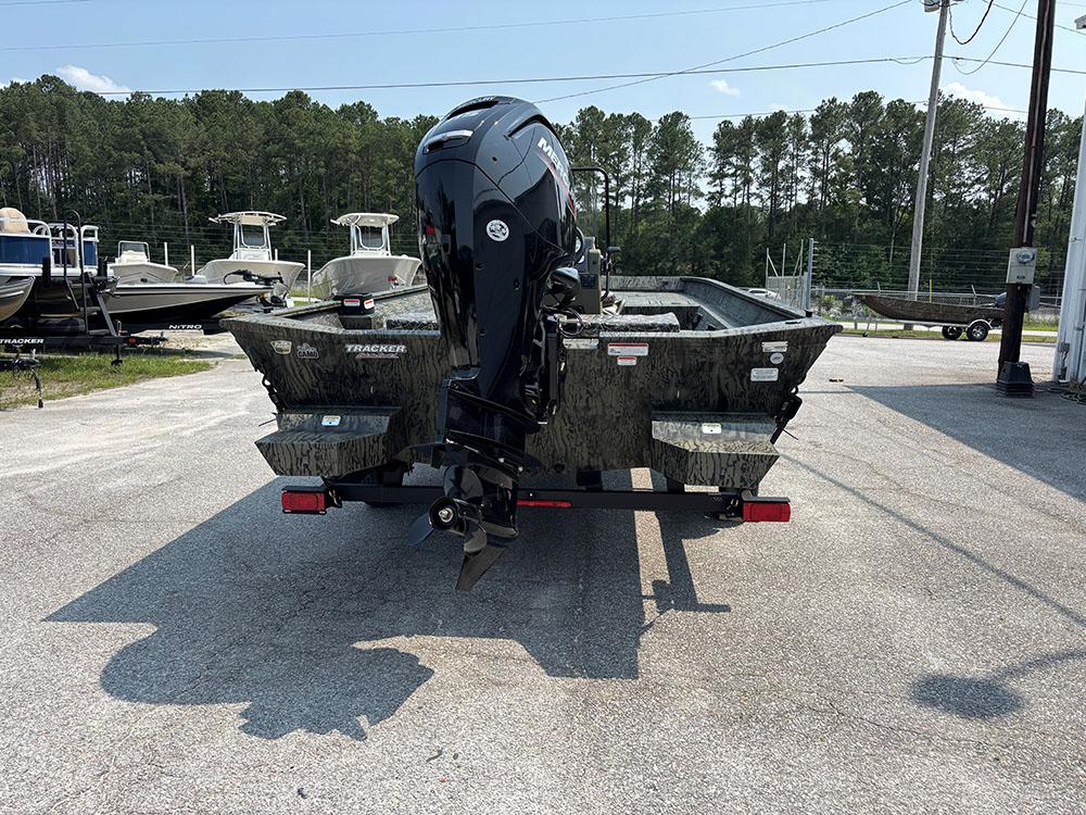 2025 Tracker Grizzly 2072 CC boat with outboard motor, parked outdoors.