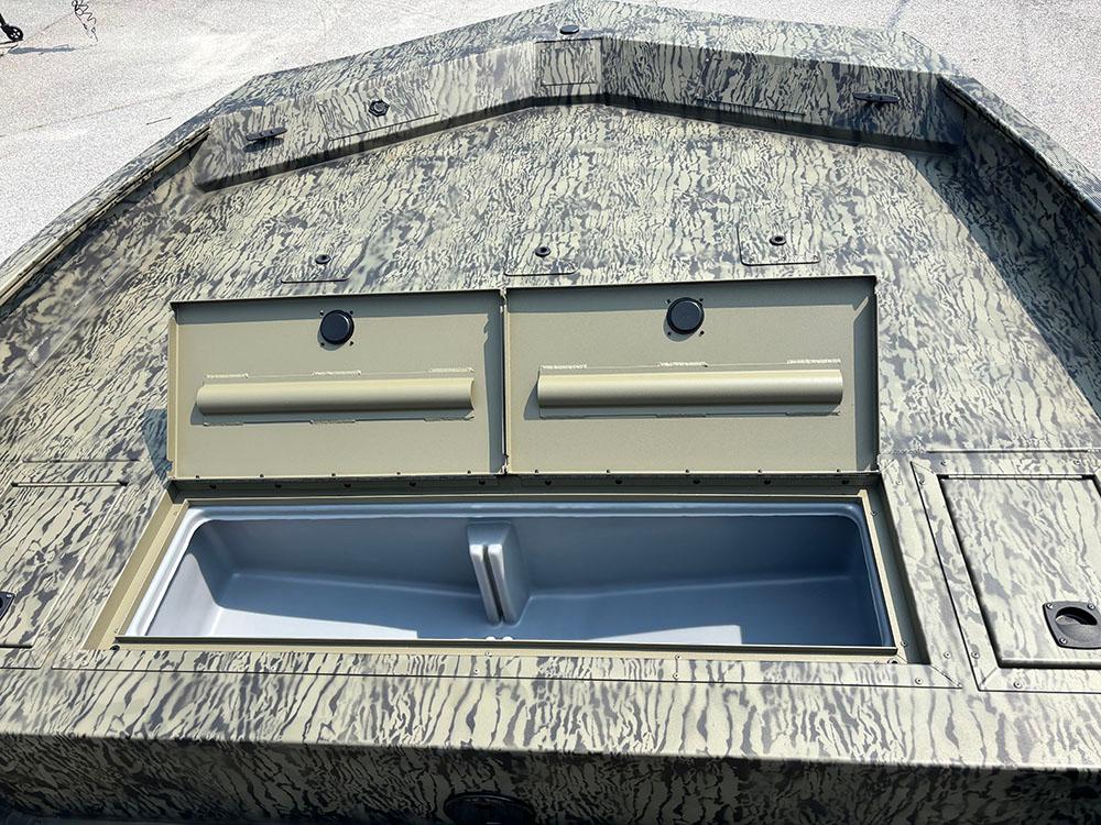 2025 Tracker Grizzly 2072 CC boat with open storage compartments on a textured deck.