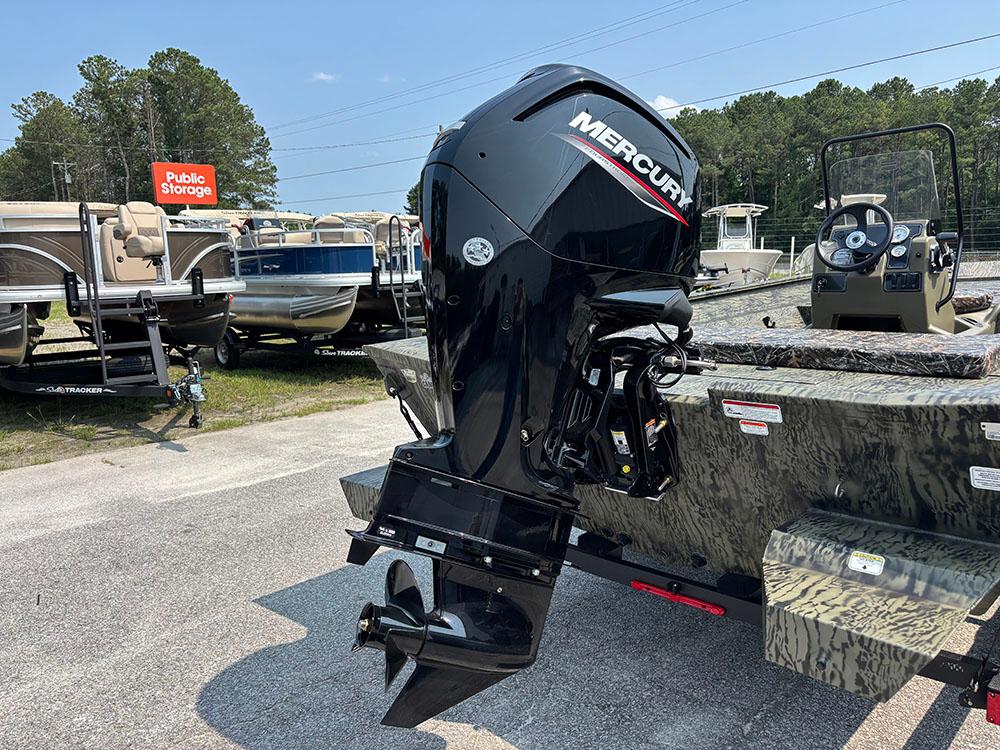 2025 Tracker Grizzly 2072 CC boat with Mercury outboard motor in a storage lot.
