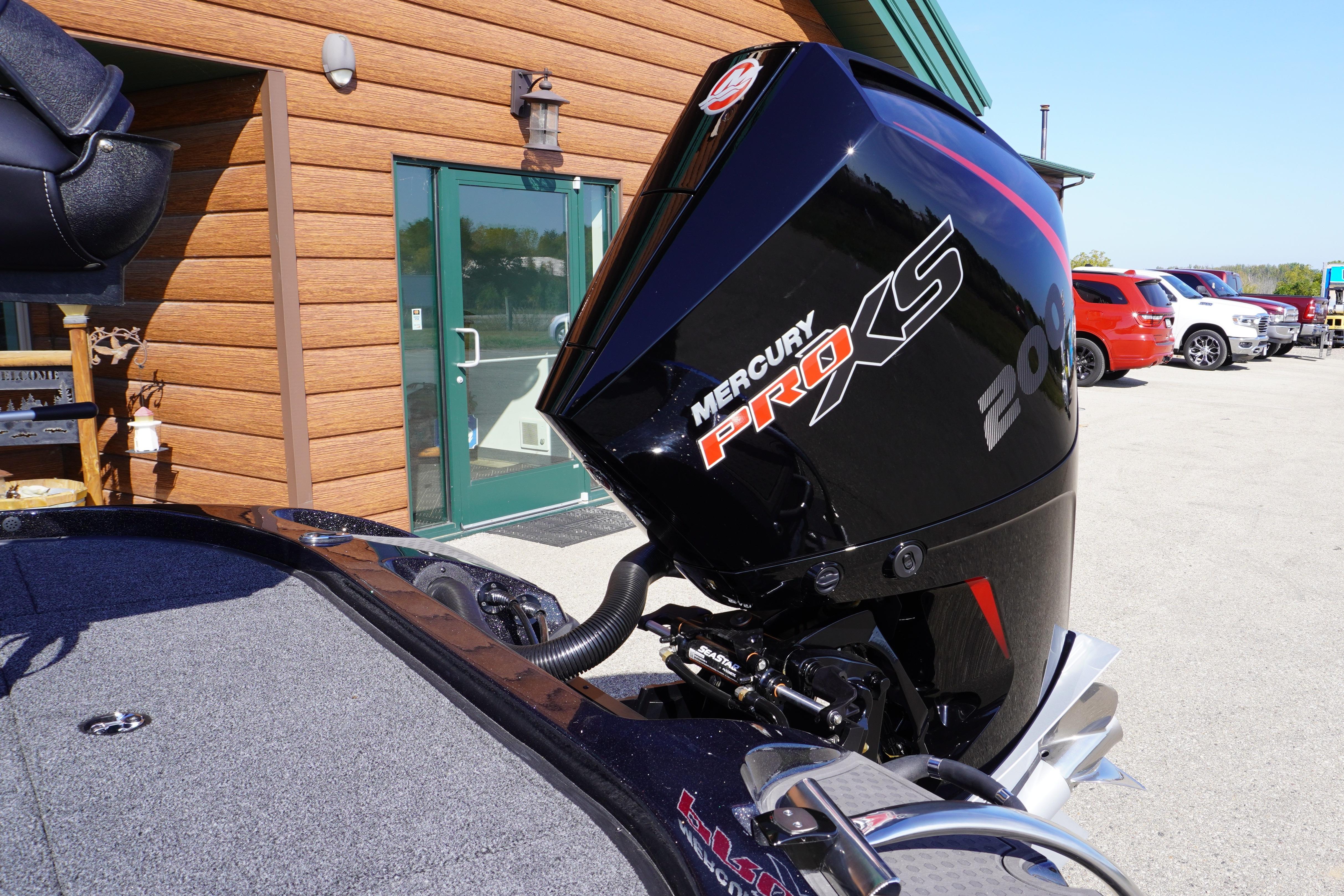 2024 Nitro Z19 boat with Mercury Pro XS 200 engine, parked outside a wooden building.