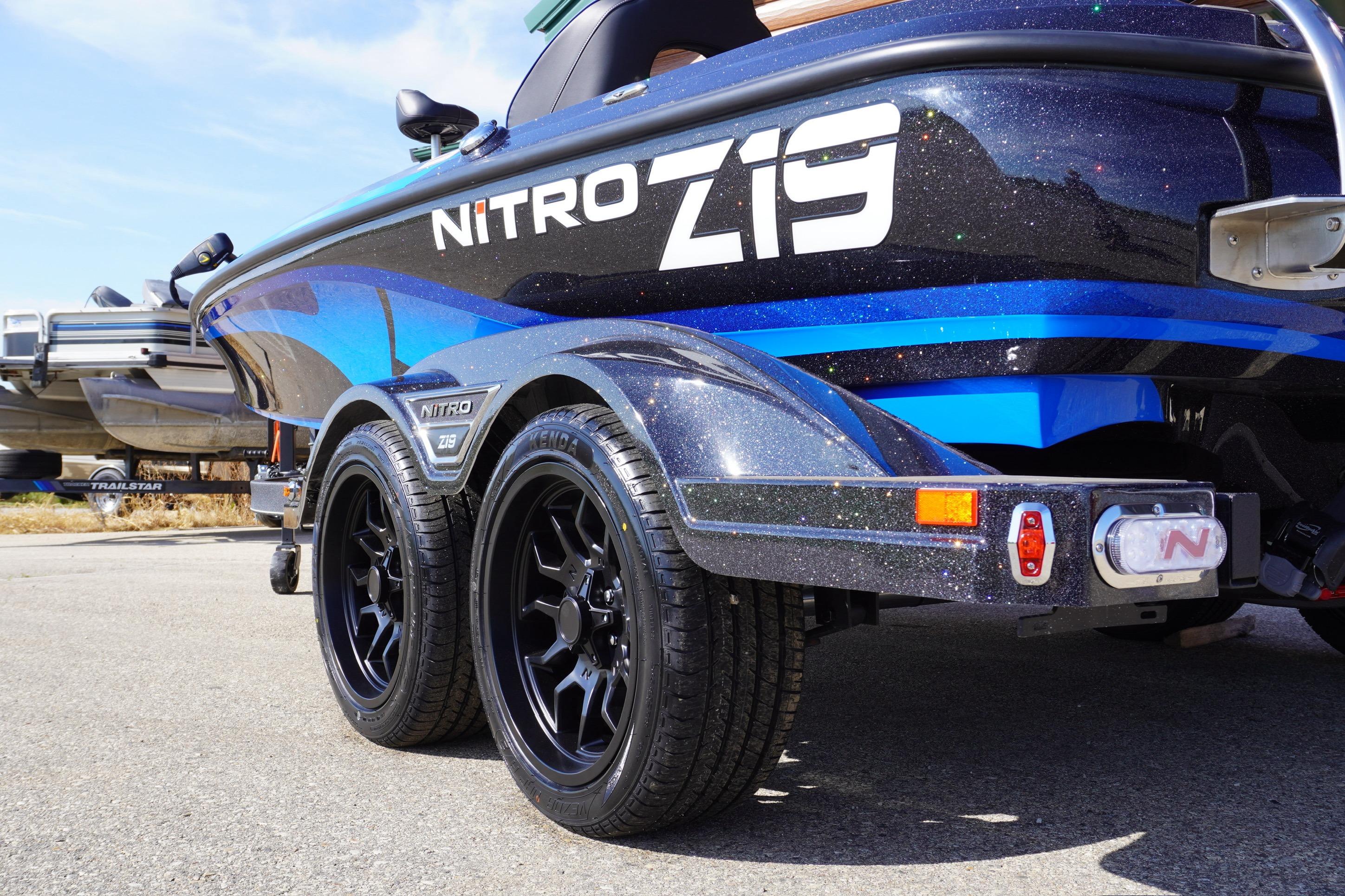2024 Nitro Z19 boat with sleek design and dual axle trailer on pavement.