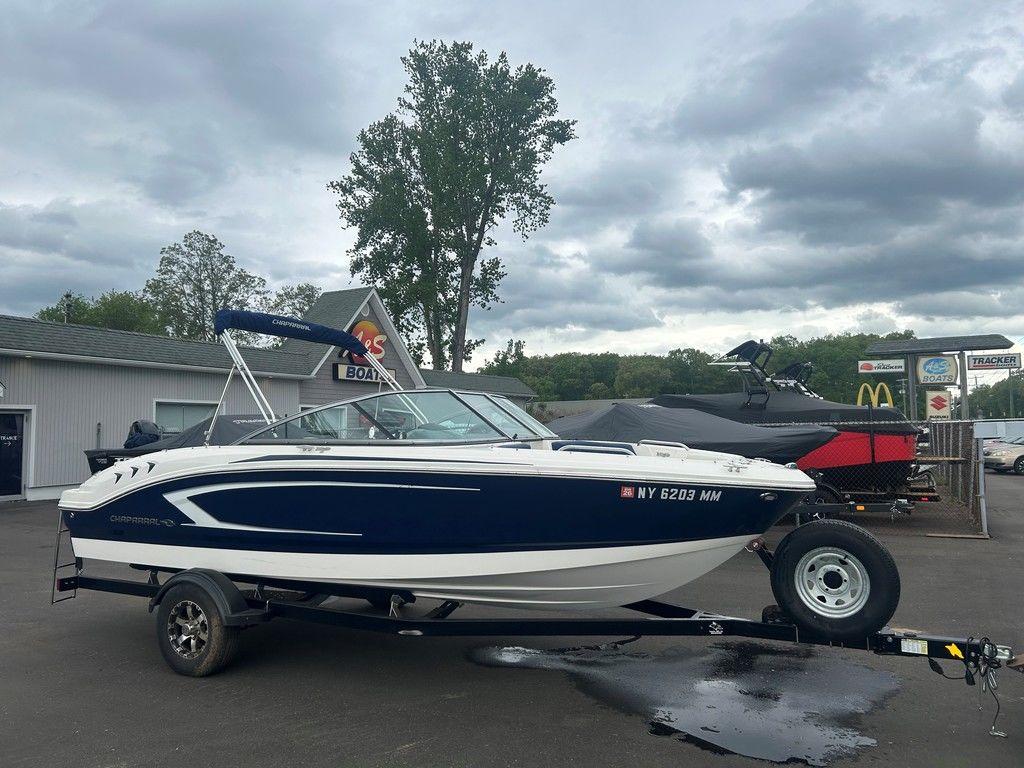 2017 Chaparral 21 H2O Sport boat on trailer, parked outdoors under cloudy sky.