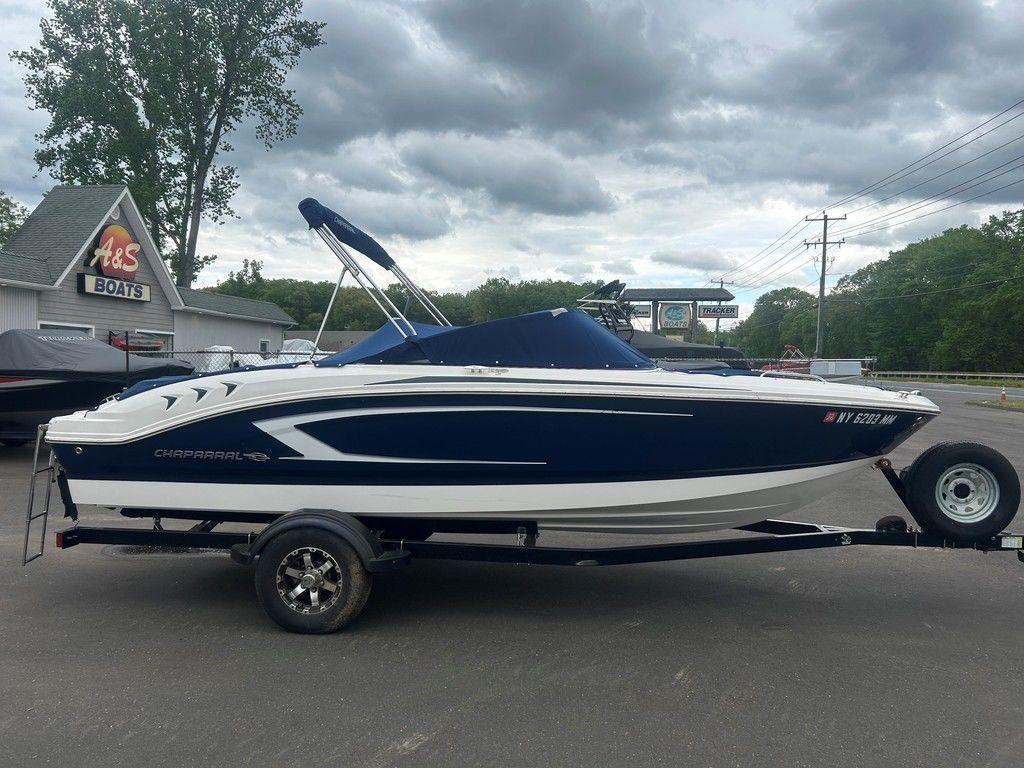 2017 Chaparral 21 H2O Sport boat on trailer, parked outdoors under cloudy sky.