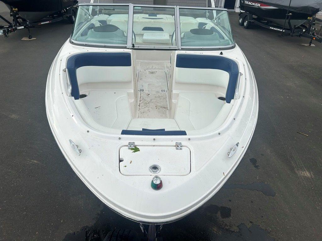 2017 Chaparral 21 H2O Sport boat, white with blue interior, parked on pavement.