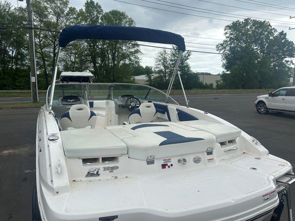 2017 Chaparral 21 H2O Sport boat with blue and white seating, parked outdoors.