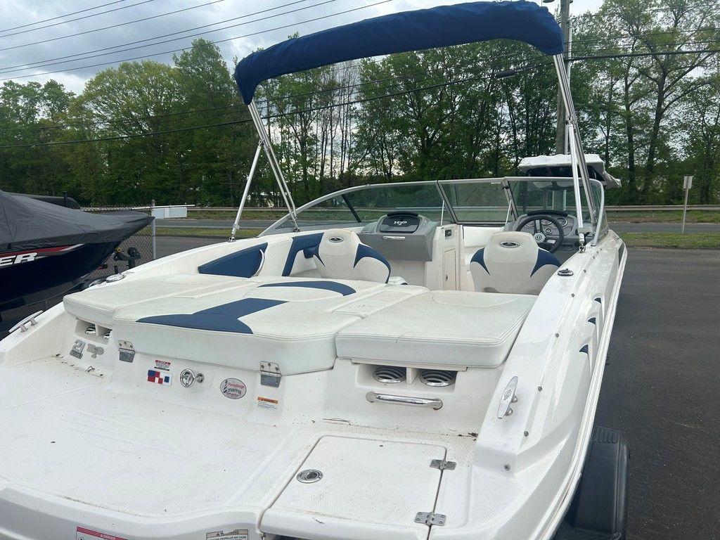2017 Chaparral 21 H2O Sport boat with blue and white seating, parked outdoors.