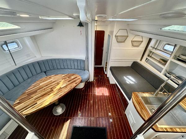 Interior of 1983 Tayana 55 yacht with elegant wood flooring and modern seating.