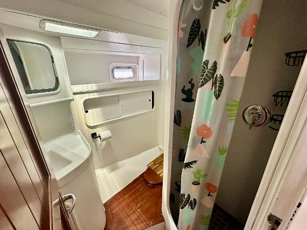 Bathroom interior of 1983 Tayana 55 yacht with shower and wooden flooring.