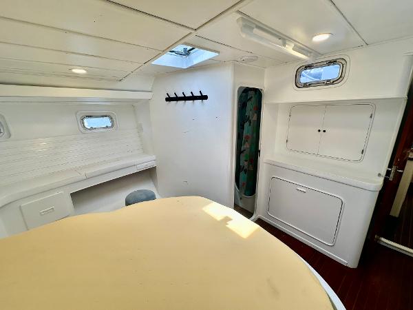 Interior of 1983 Tayana 55 yacht, featuring white walls, windows, and a skylight.