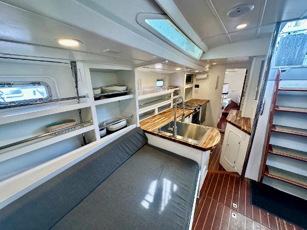 Interior of 1983 Tayana 55 yacht with modern kitchen and cozy seating area.