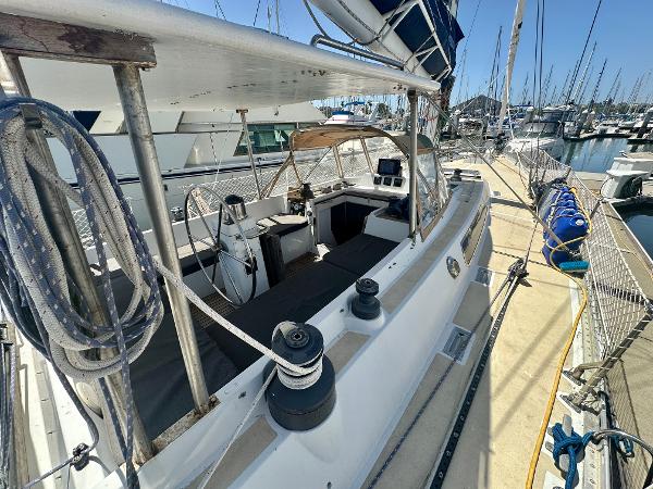 1983 Tayana 55 sailboat docked at marina, featuring spacious deck and cockpit area.