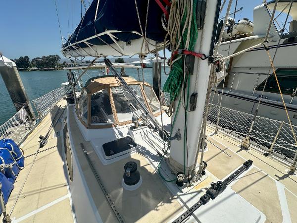 Sailboat deck view of 1983 Tayana 55, docked with clear skies and calm waters.