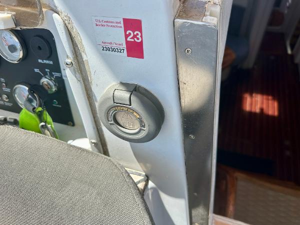 Control panel of a 1983 Tayana 55 yacht with ignition switch and customs sticker.