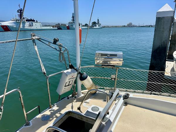 Sailboat deck view with grill, Tayana 55, 1983, docked near coast guard ships.