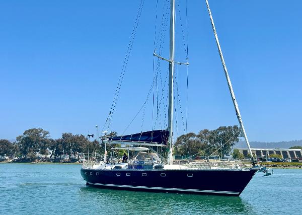 Sailing yacht Tayana 55, 1983 model, on calm water under clear blue sky.