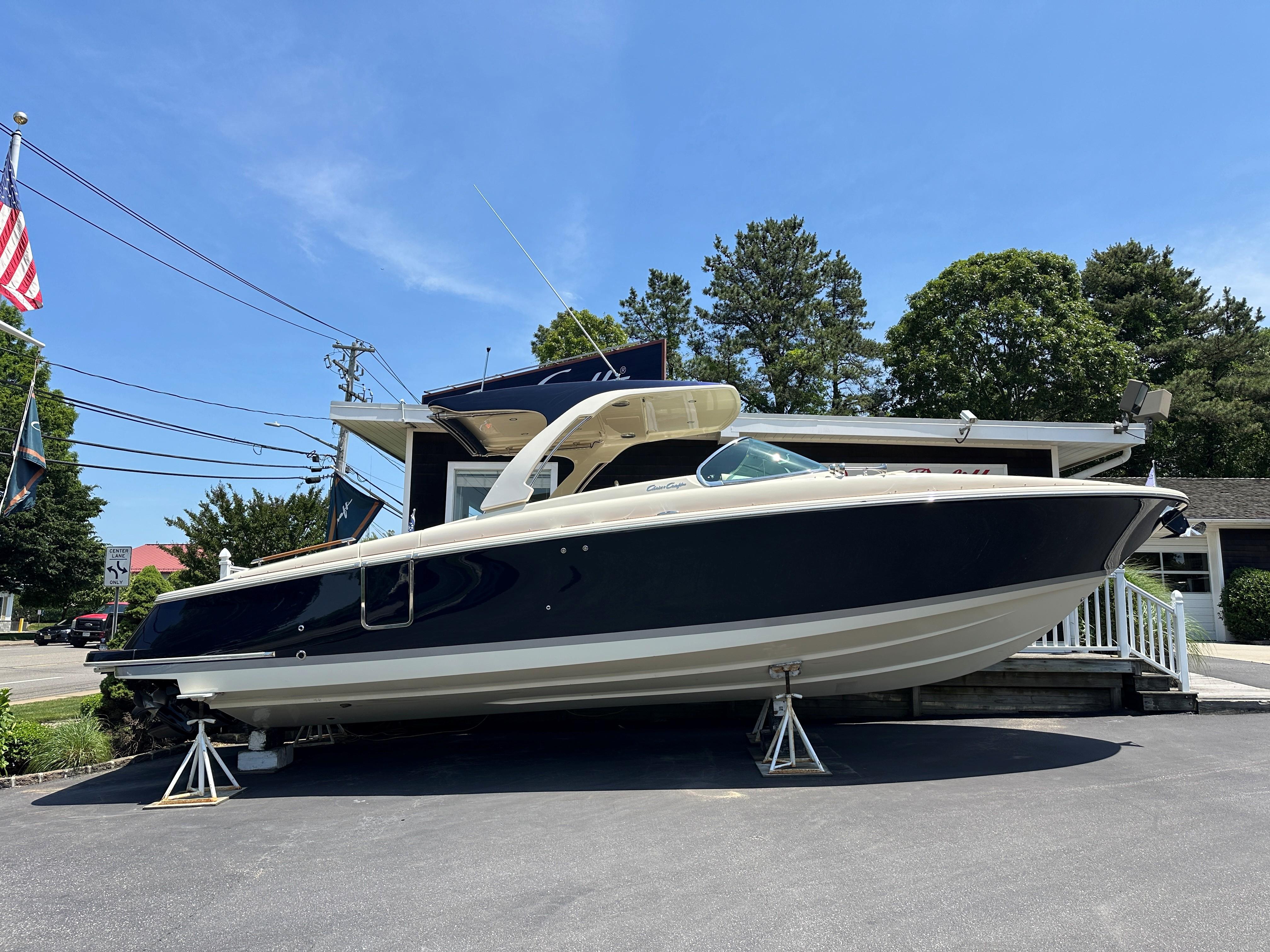 2025 Chris-Craft Launch 35 GT boat displayed outdoors on stands, under clear blue sky.