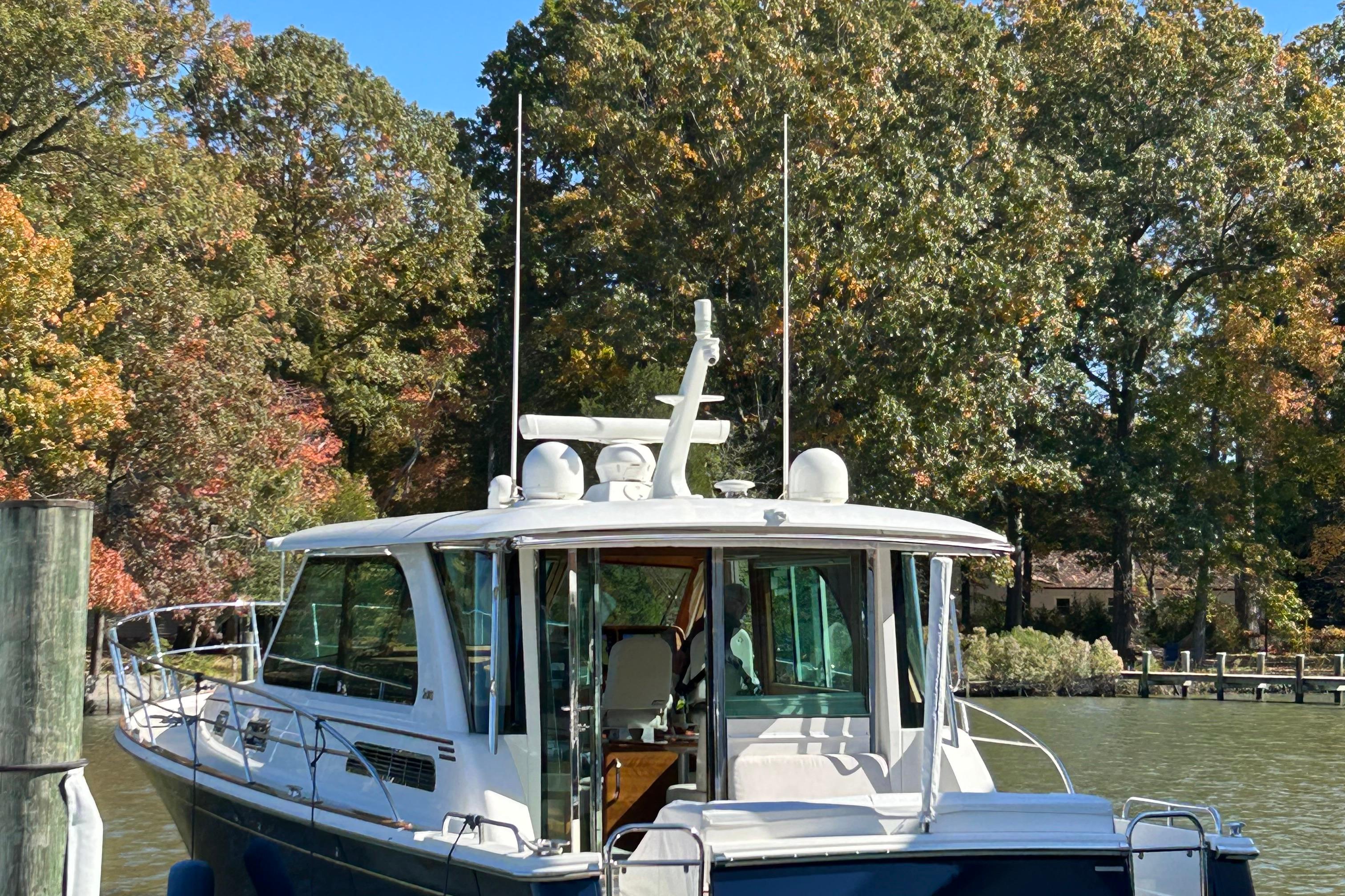 2022 Sabre 45 Salon Express yacht docked by autumn trees.