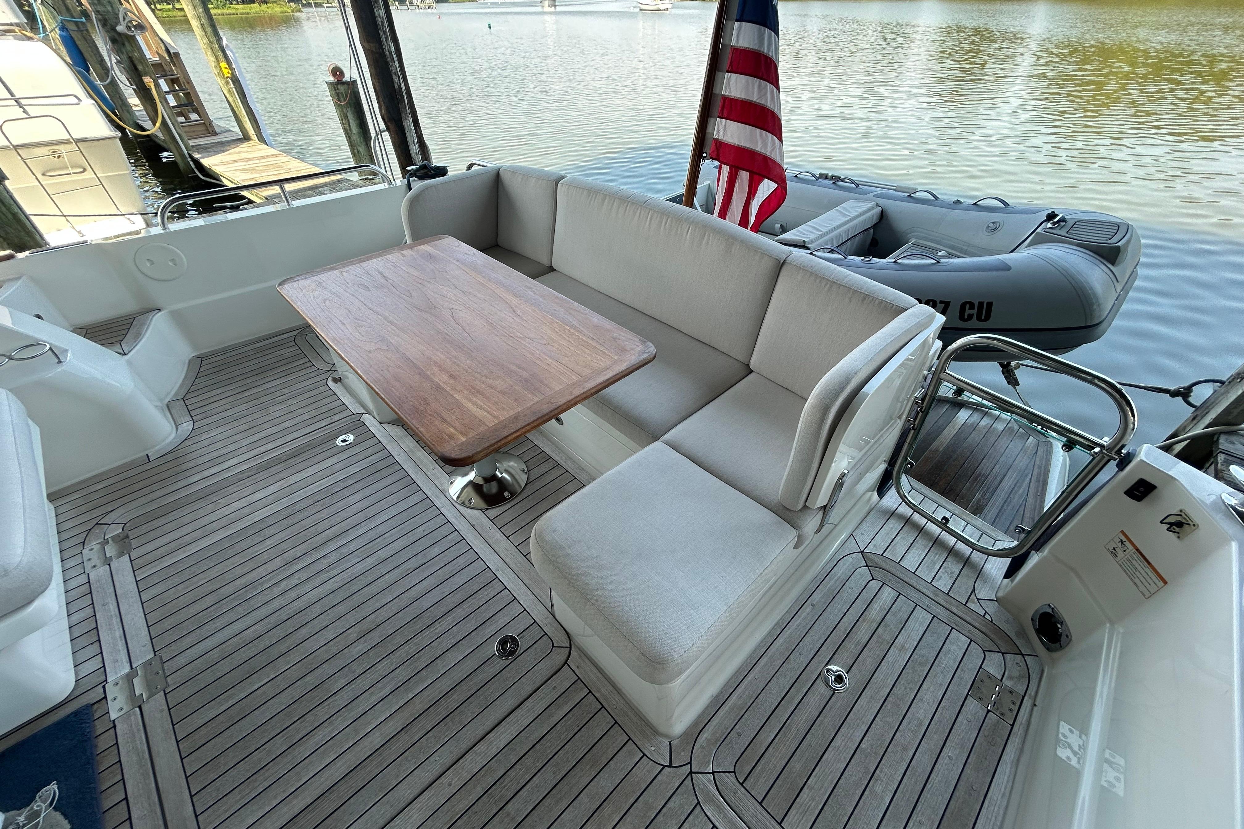 2022 Sabre 45 Salon Express yacht deck with seating, table, and American flag.
