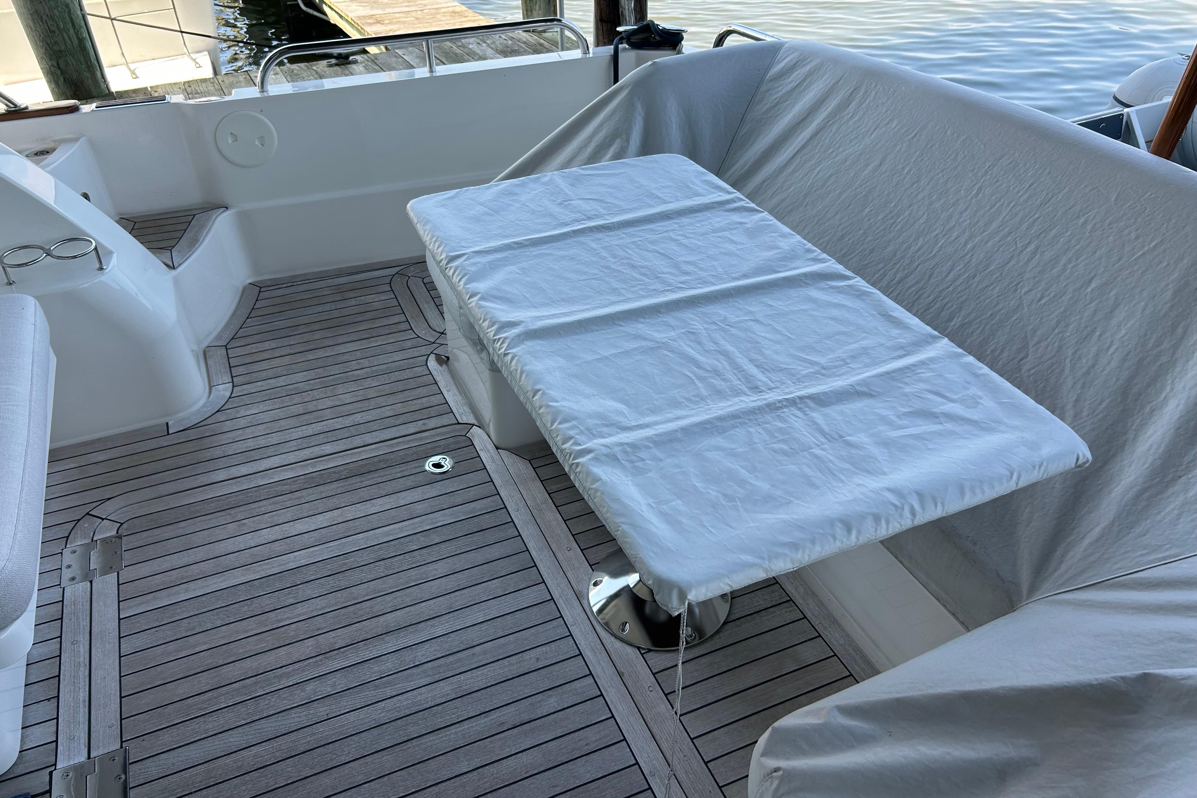2022 Sabre 45 Salon Express yacht deck with covered table and seating area.