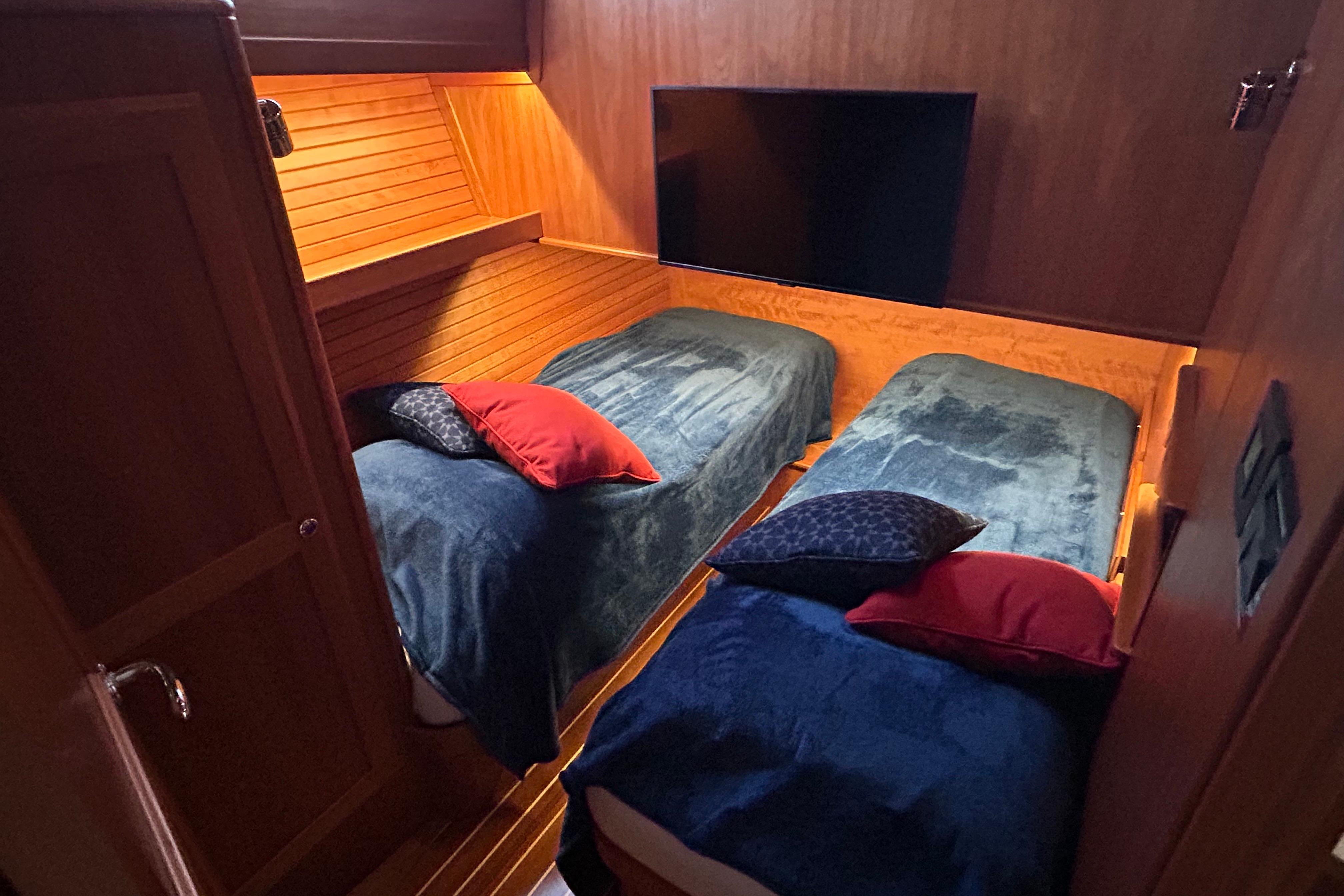 2022 Sabre 45 Salon Express cabin with twin beds, cozy lighting, and plush pillows.