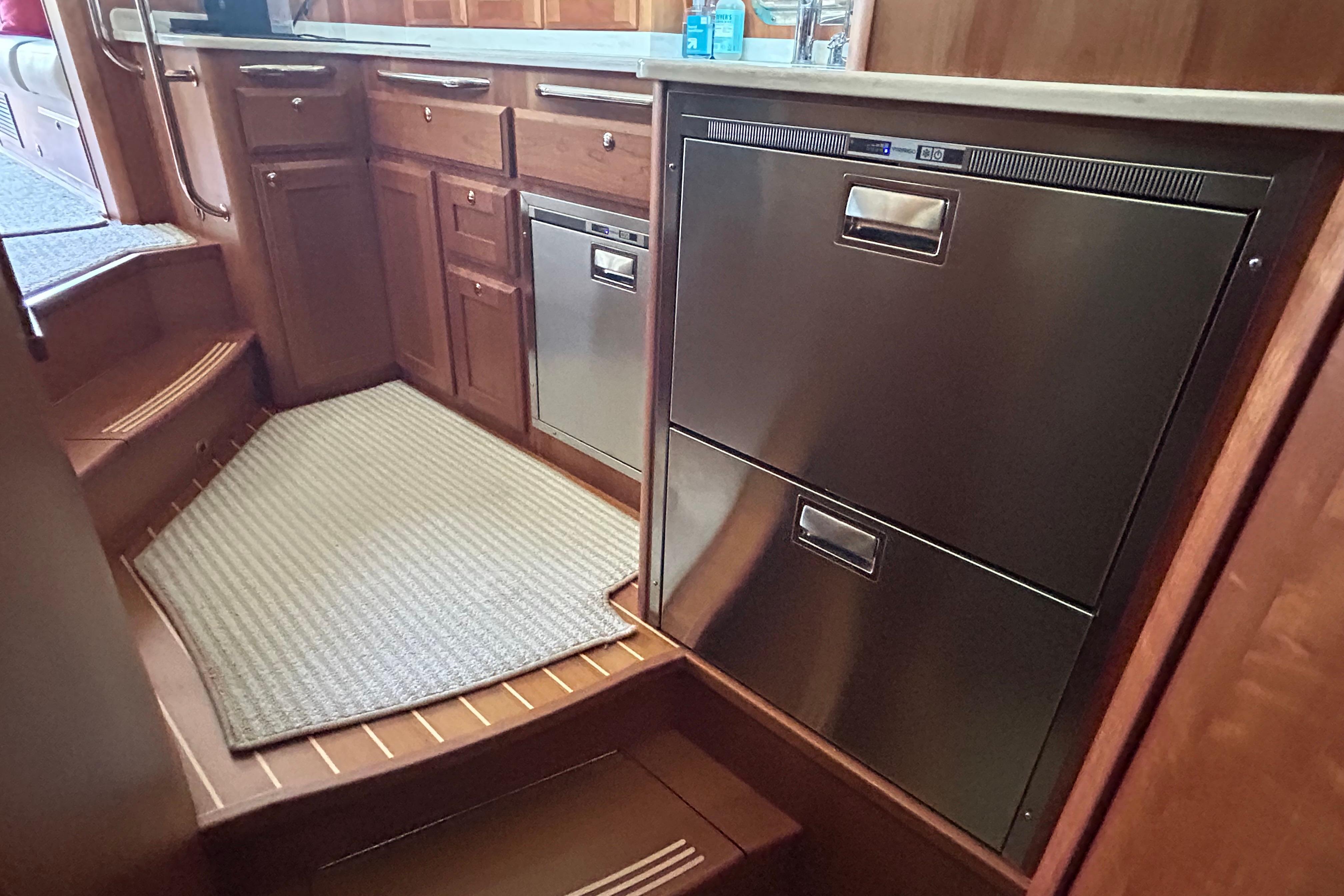 2022 Sabre 45 Salon Express galley with stainless steel appliances and wooden cabinetry.