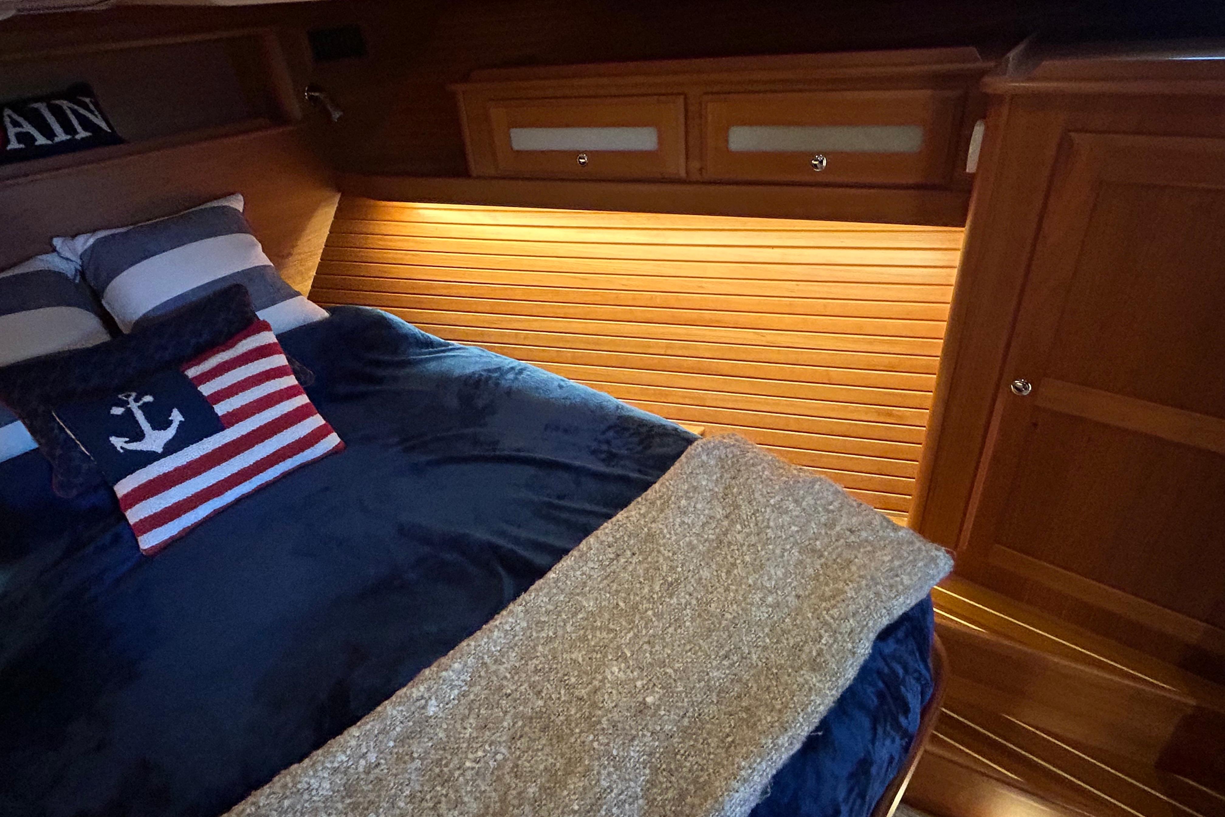 Cozy cabin interior of 2022 Sabre 45 Salon Express with nautical-themed bedding.