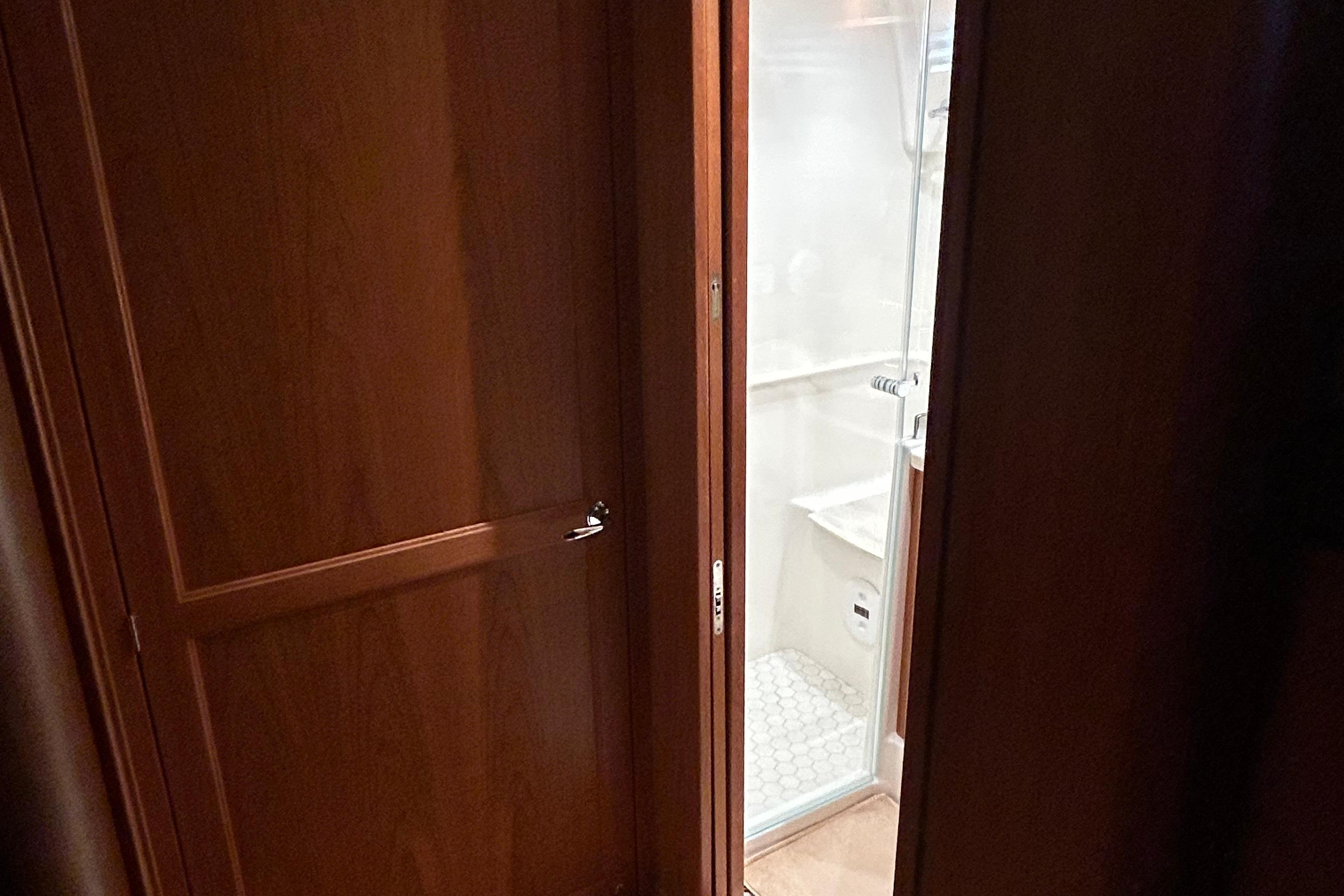 Interior view of 2022 Sabre 45 Salon Express bathroom with wooden door and shower.