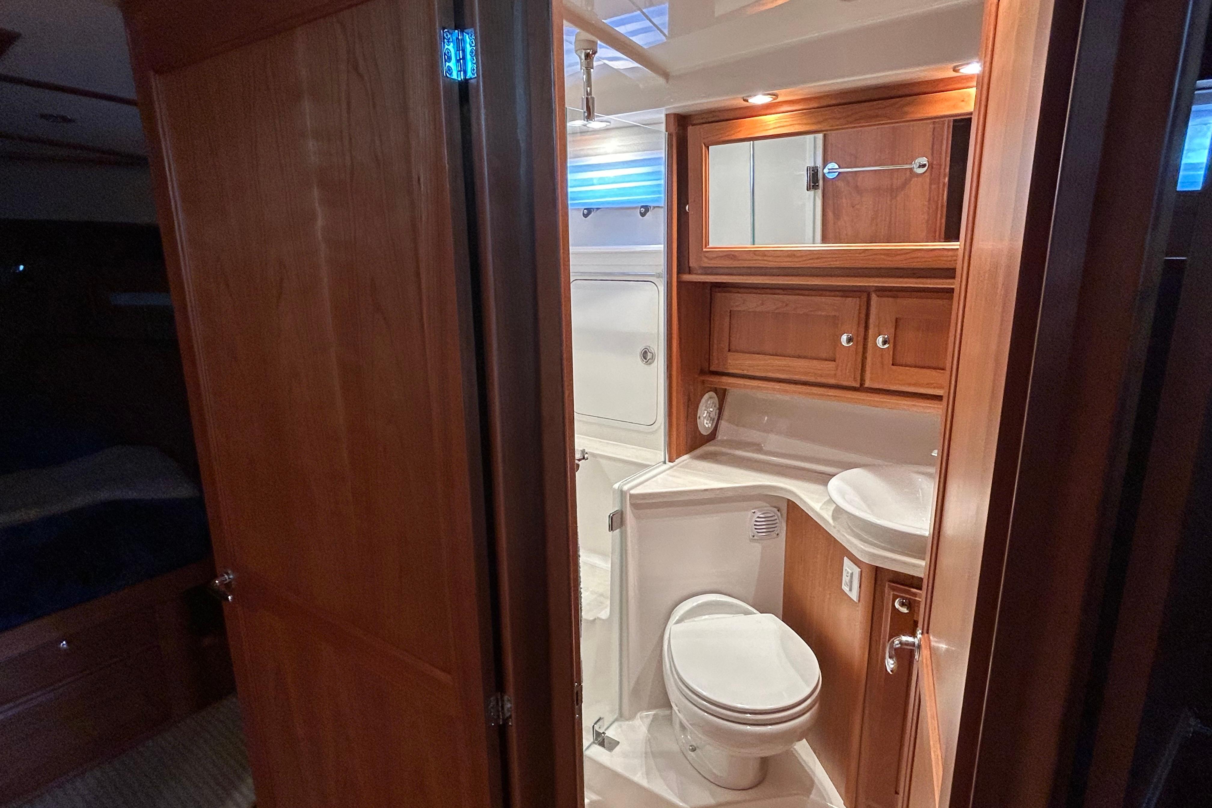 Luxurious bathroom interior of 2022 Sabre 45 Salon Express yacht, featuring wood cabinetry.