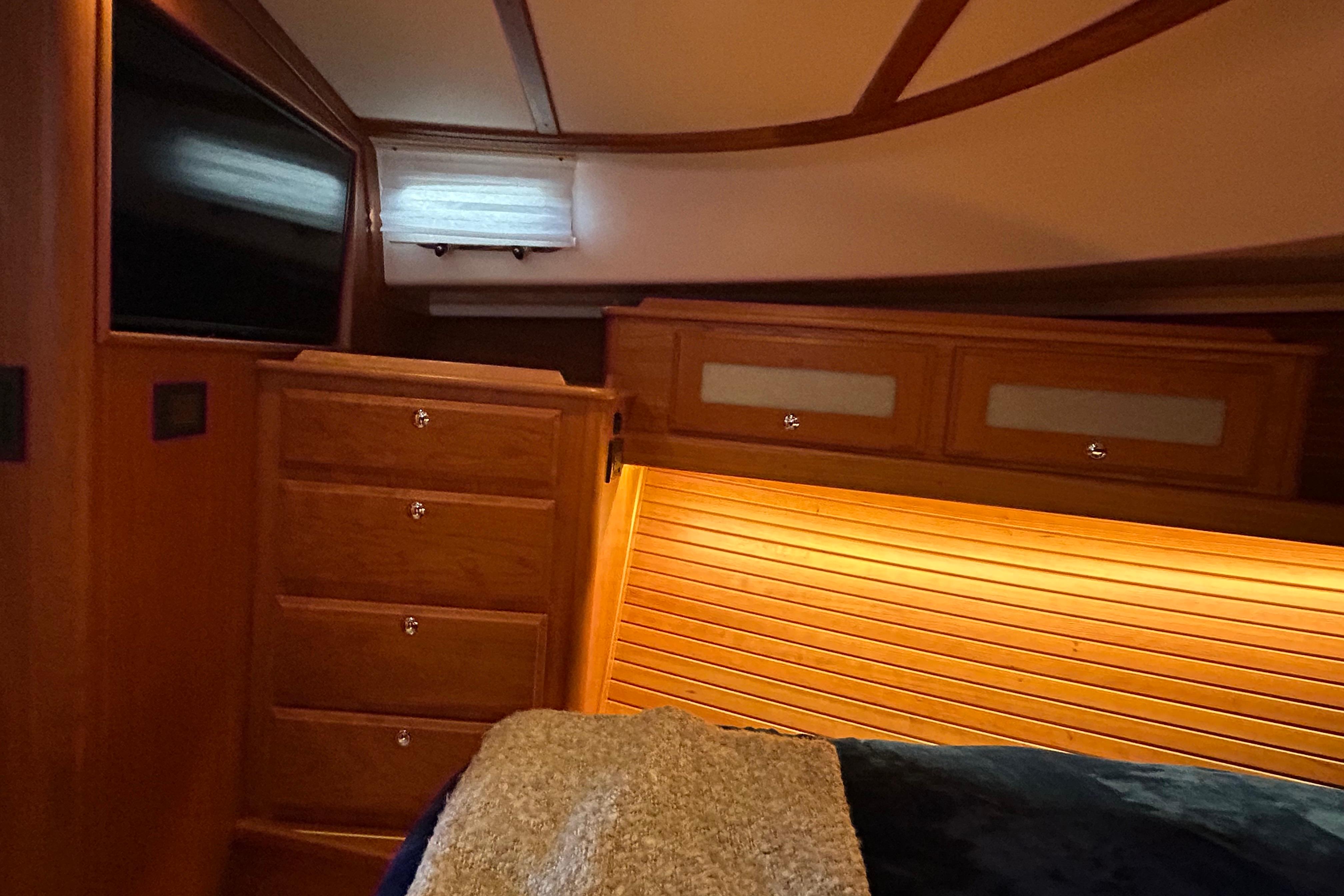 Luxurious interior of 2022 Sabre 45 Salon Express yacht with wood cabinetry and ambient lighting.