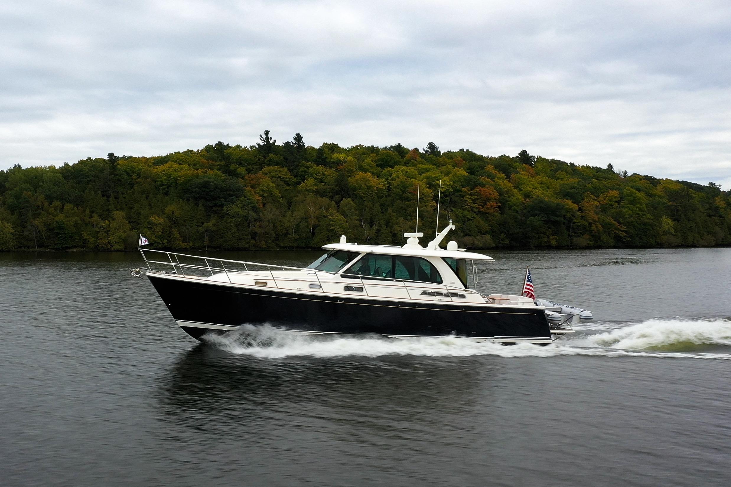 2022 Sabre 45 Salon Express cruising on a scenic lake with lush green forest backdrop.