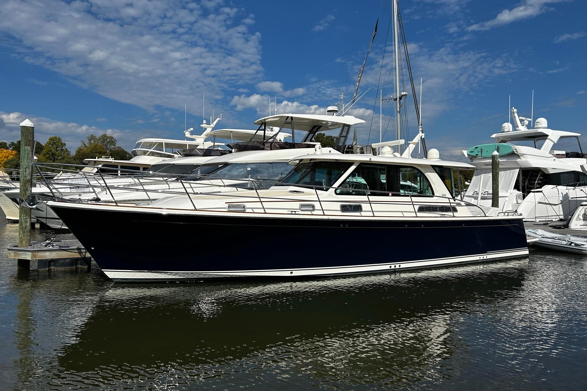 2022 Sabre 45 Salon Express yacht docked at marina under blue sky.