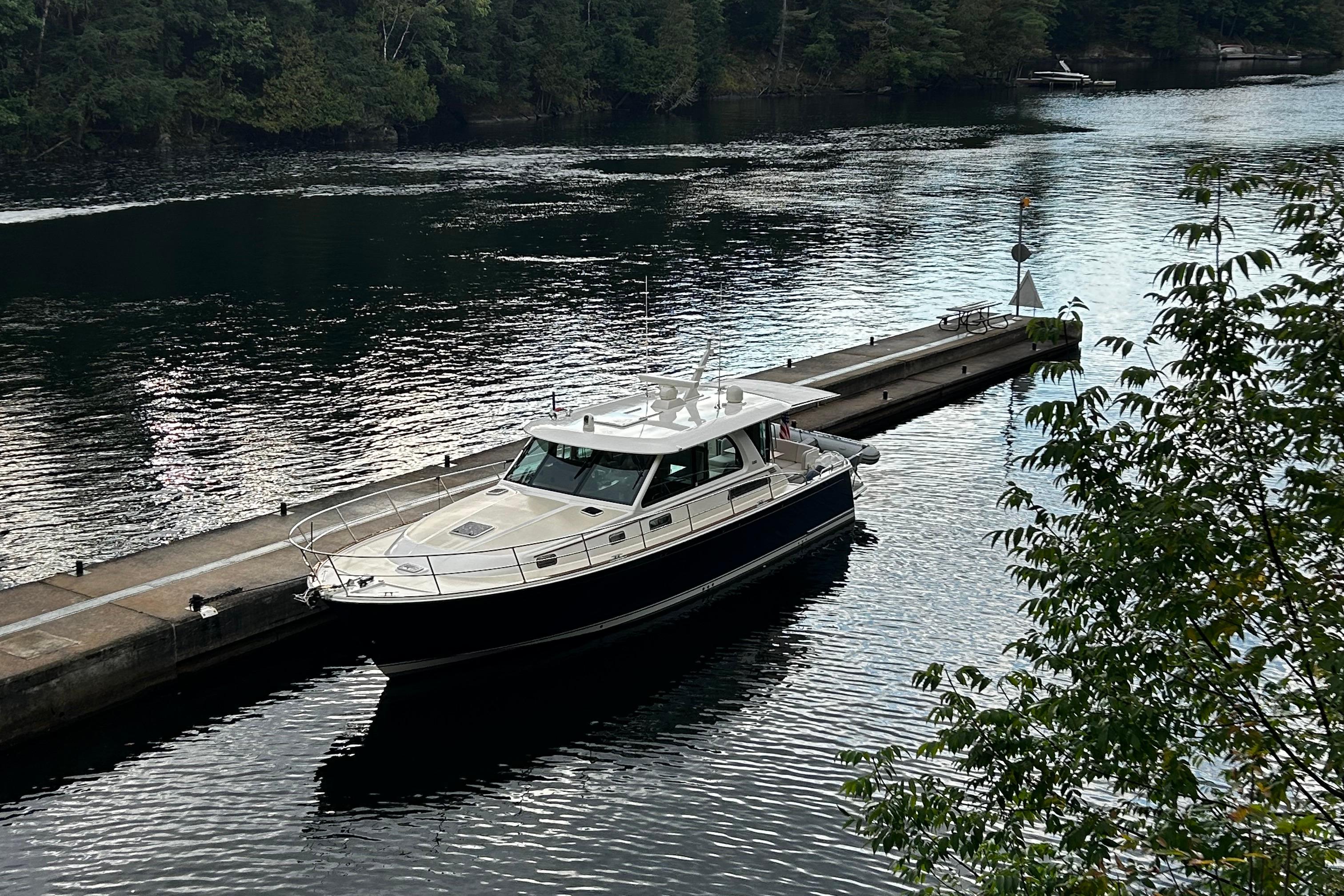 2022 Sabre 45 Salon Express yacht docked on a serene river.