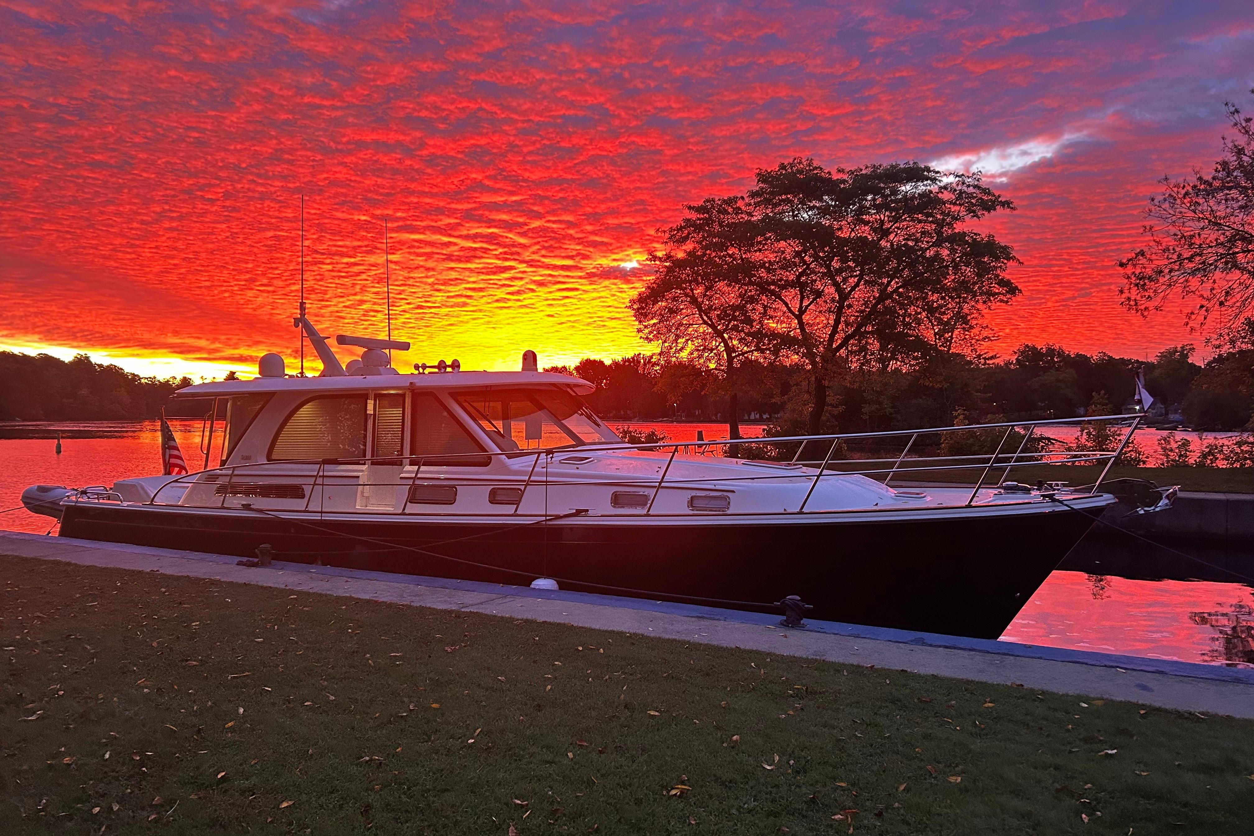 2022 Sabre 45 Salon Express yacht docked at sunset with vibrant sky.