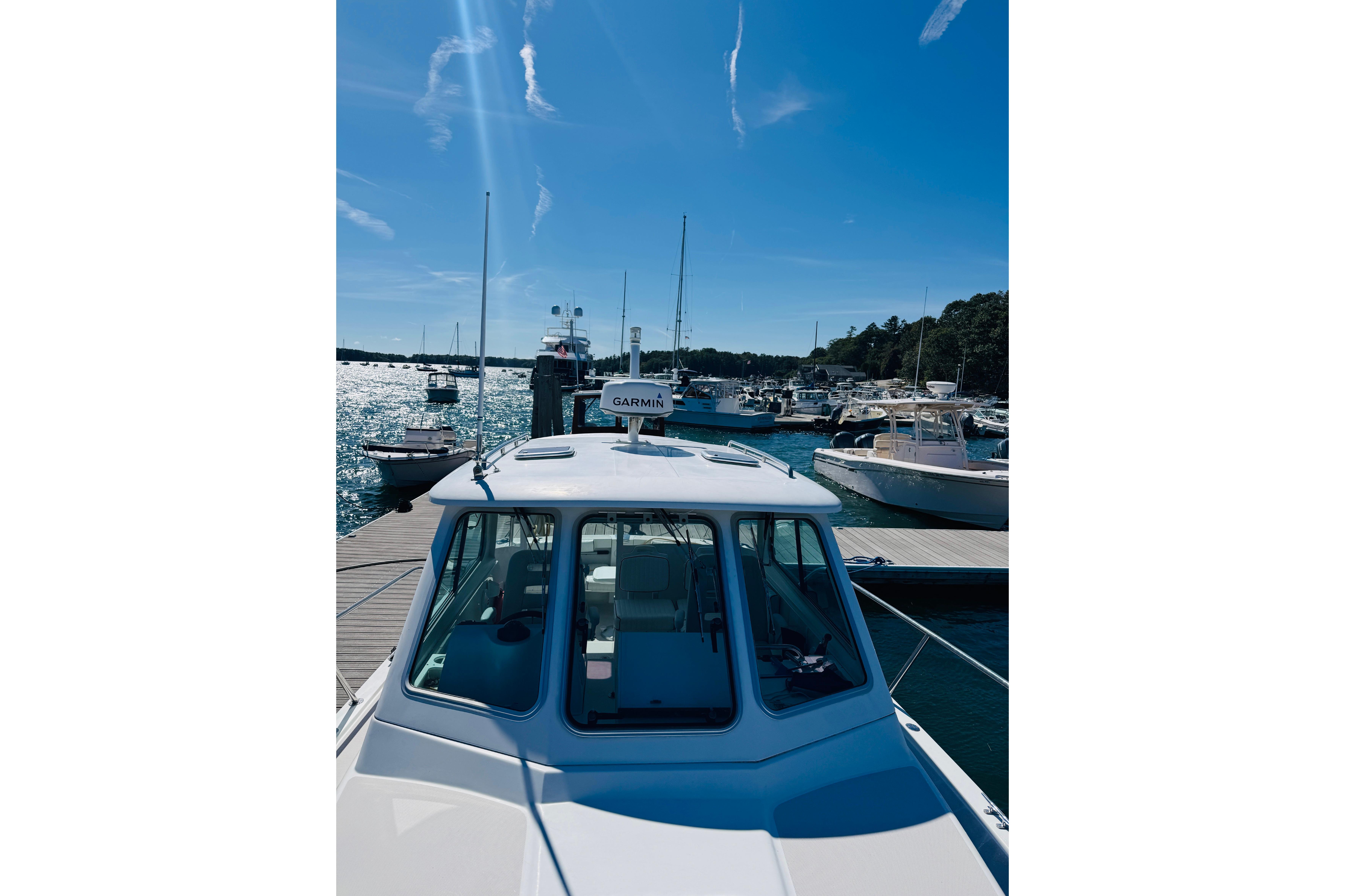 2007 Back Cove 29 boat docked at marina under clear blue sky.