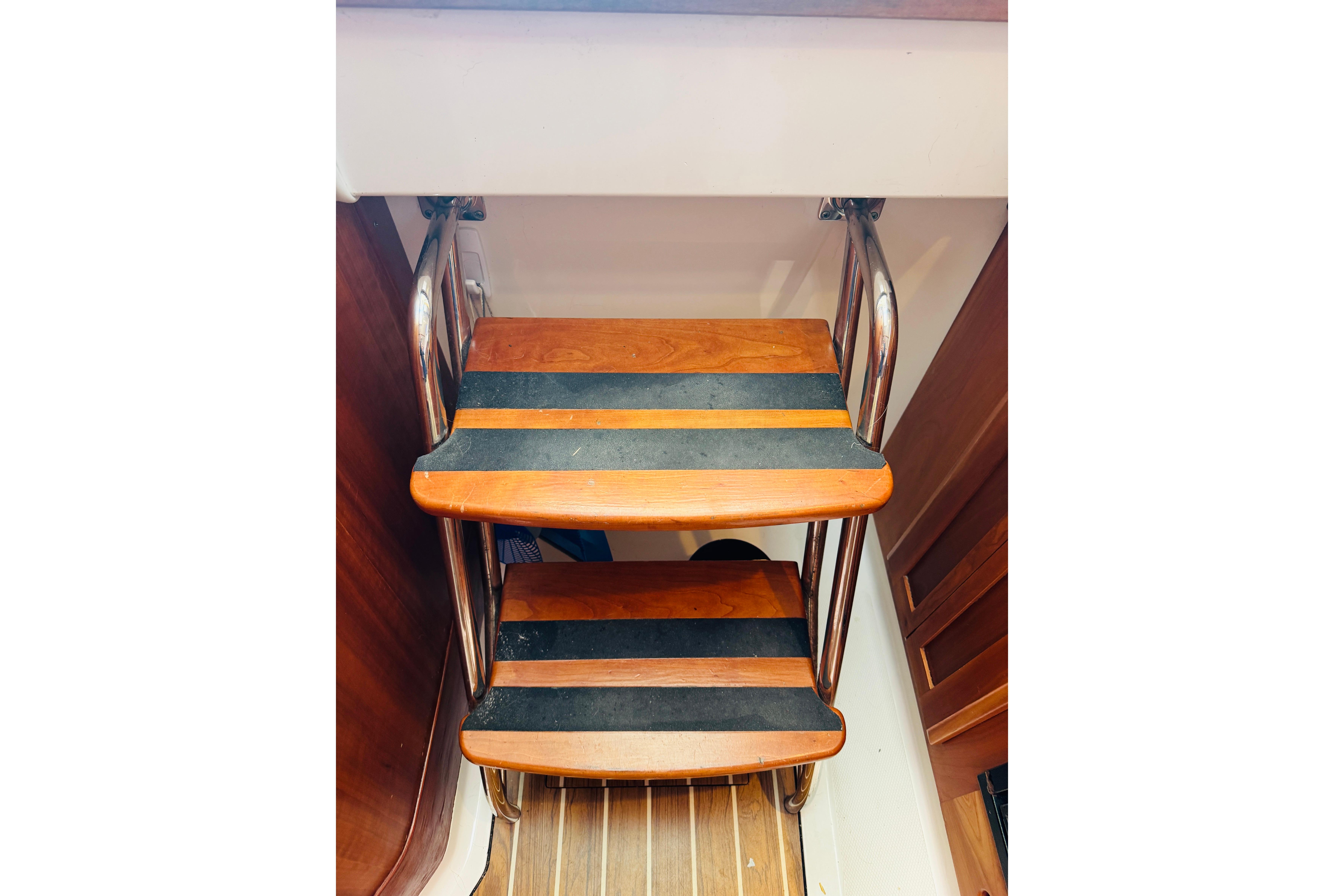 Wooden steps with metal rails on a 2007 Back Cove 29 boat interior.