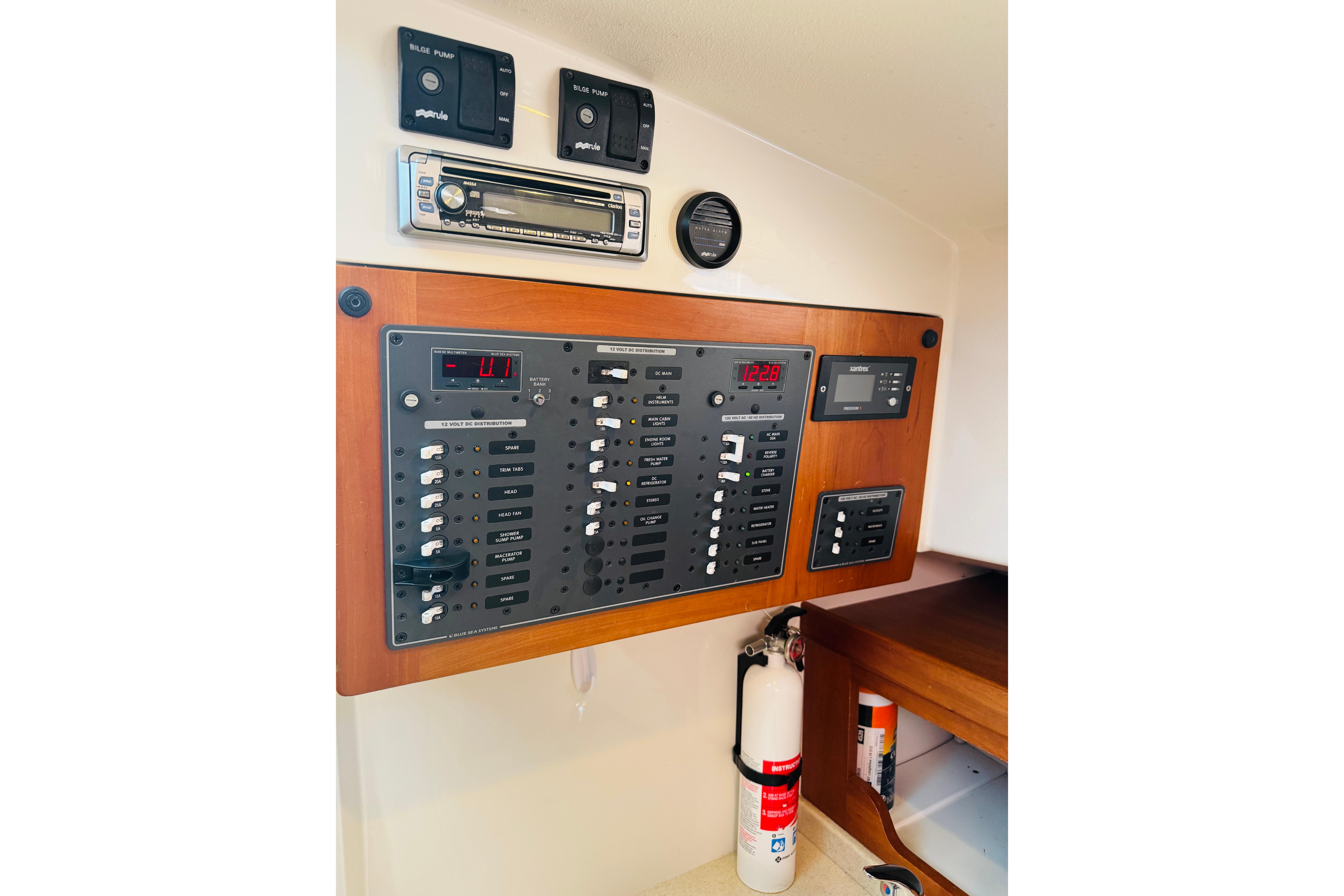 Control panel of a 2007 Back Cove 29 boat with switches and fire extinguisher.