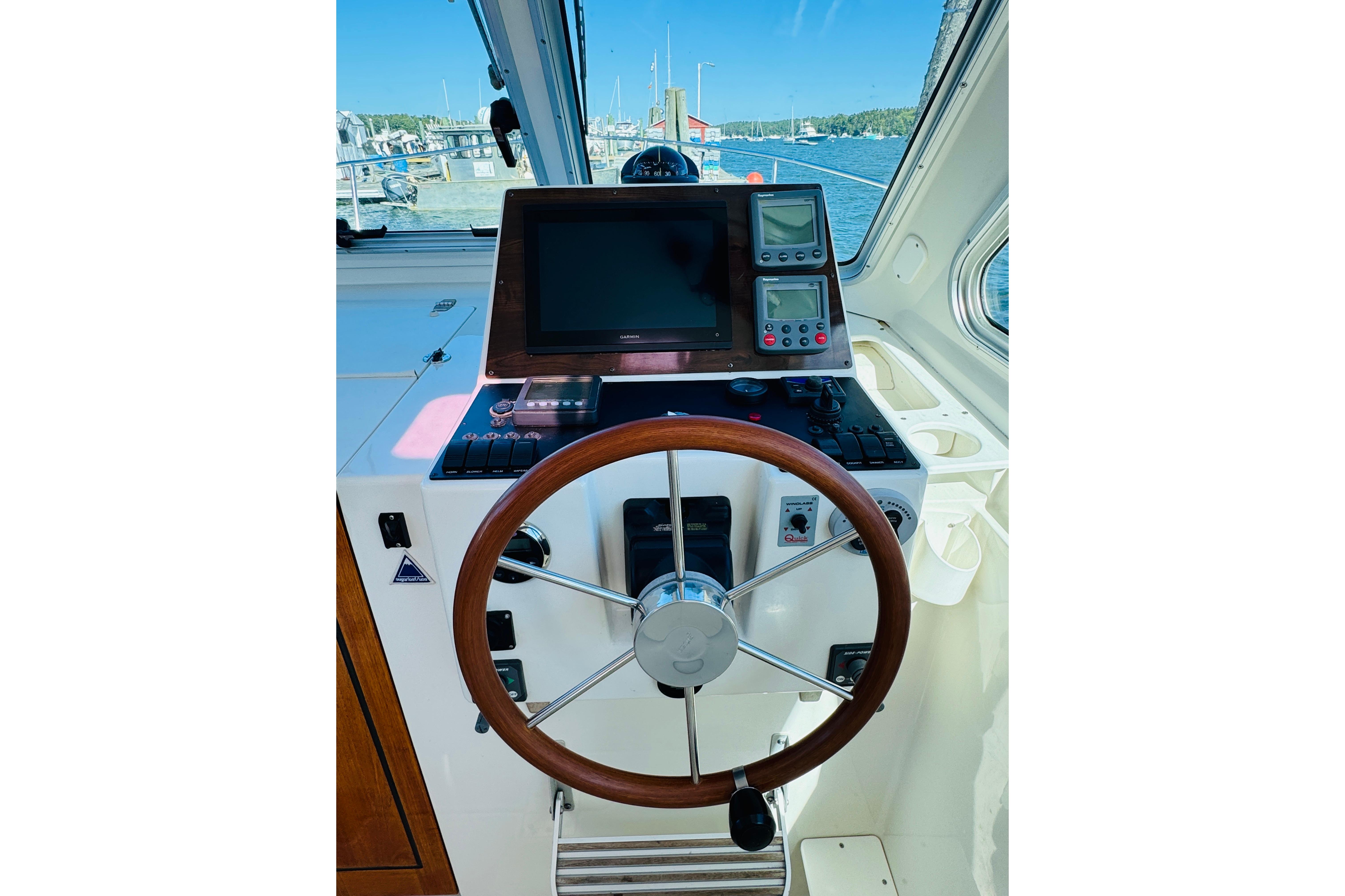 Helm of 2007 Back Cove 29 boat with steering wheel and navigation equipment.