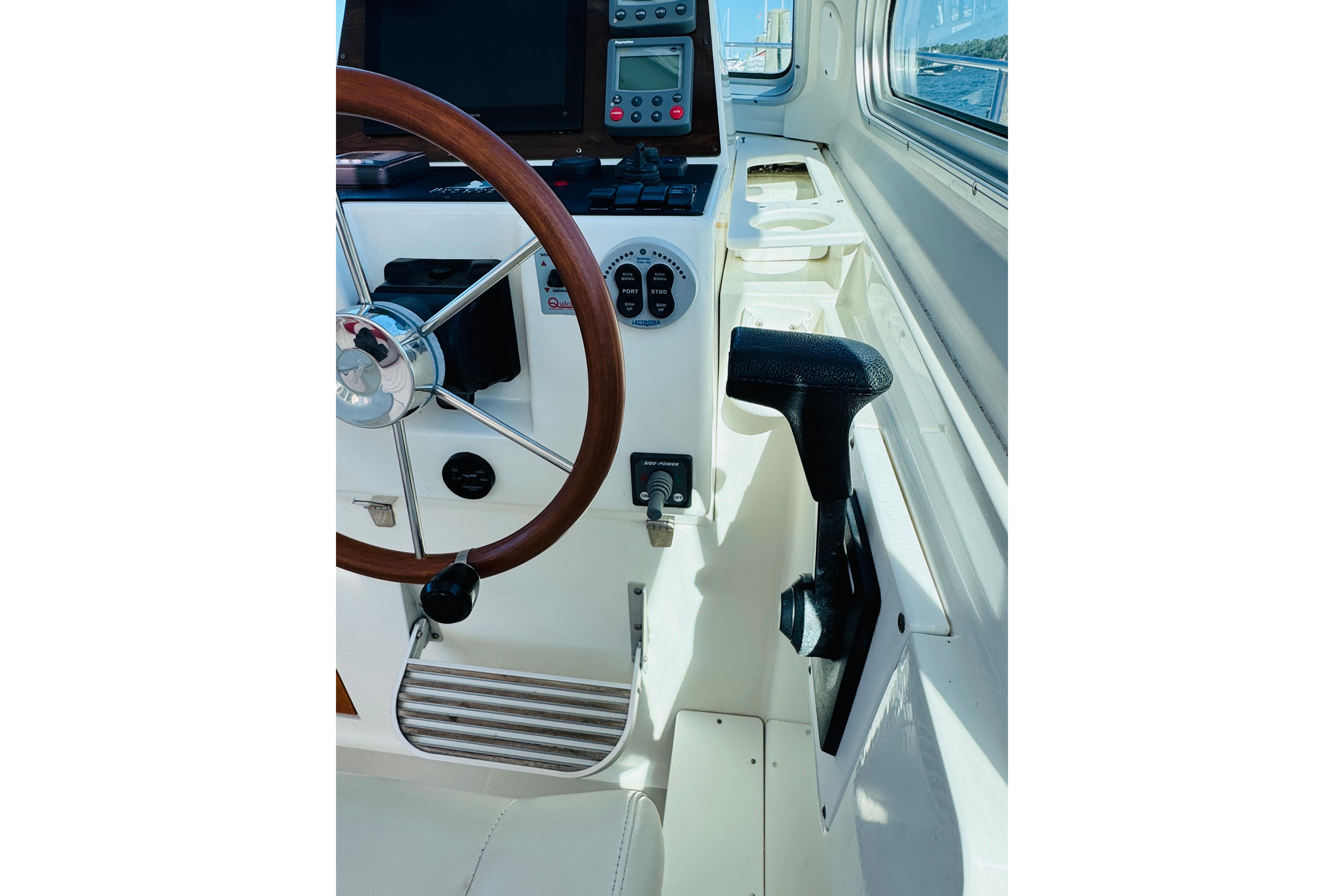 2007 Back Cove 29 boat helm with wooden steering wheel and navigation controls.