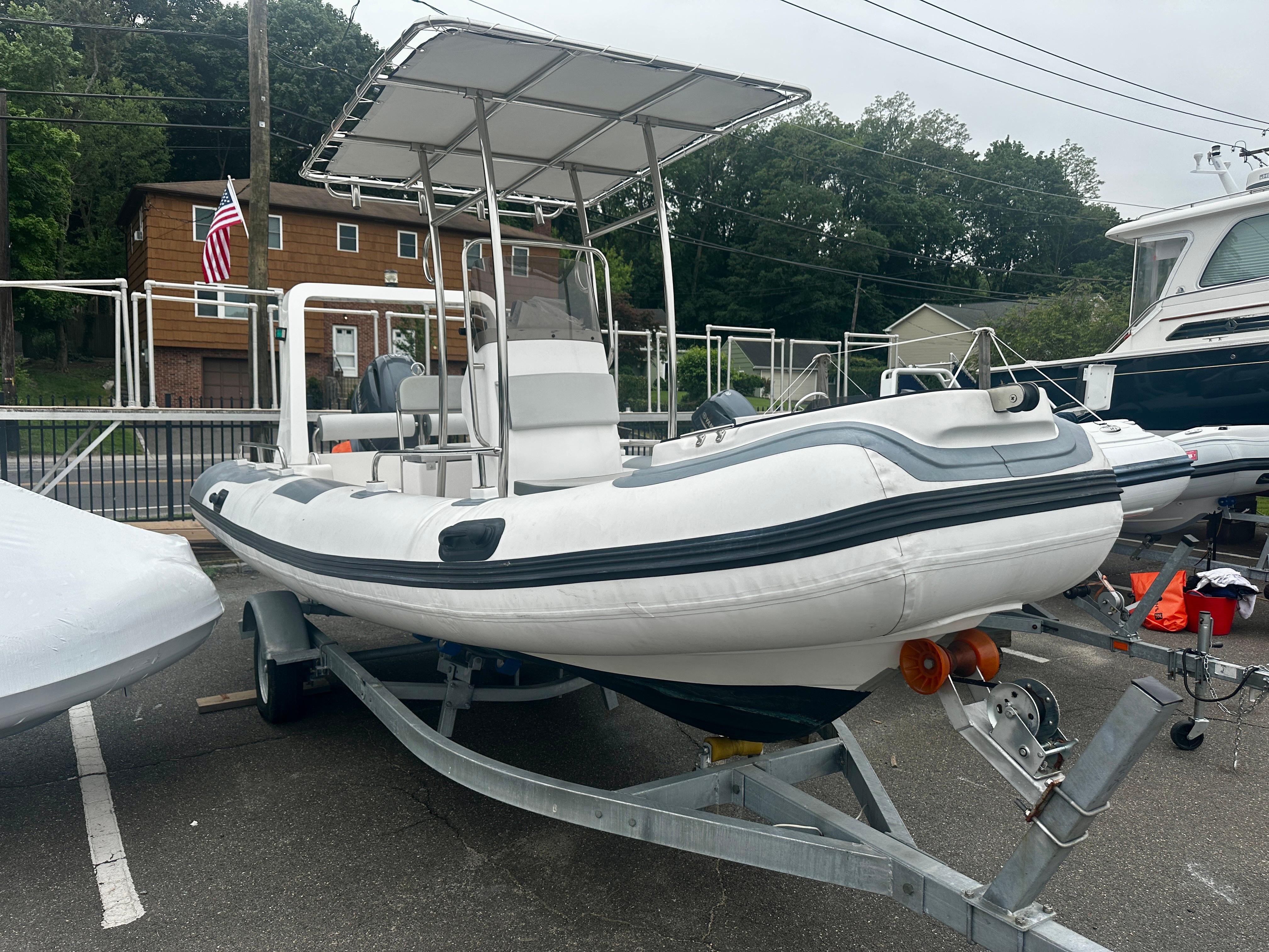 2021 Hedia Rib580 boat on trailer, parked outdoors with canopy and American flag nearby.