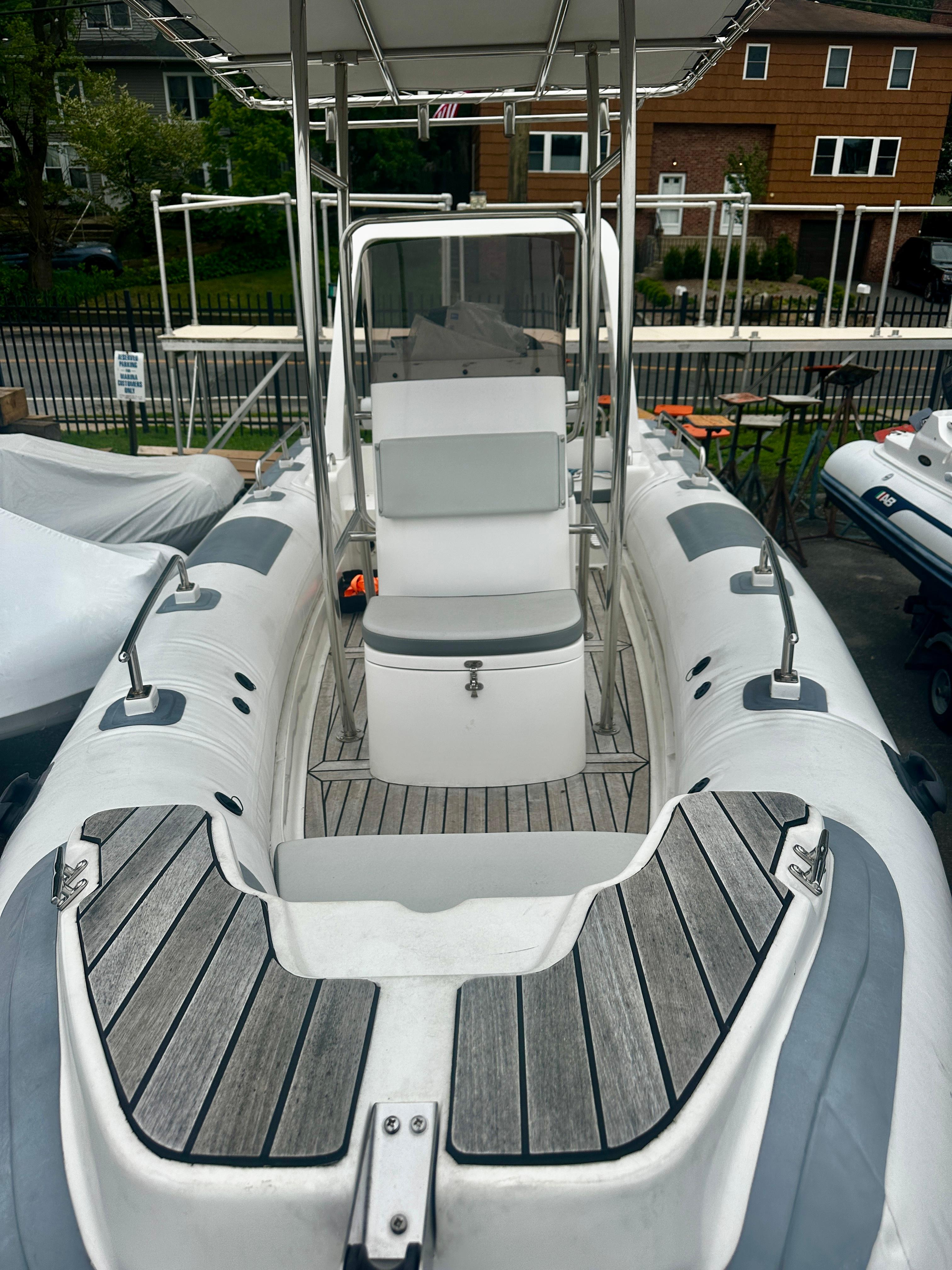 2021 Hedia Rib580 inflatable boat with seating and console, docked outdoors.