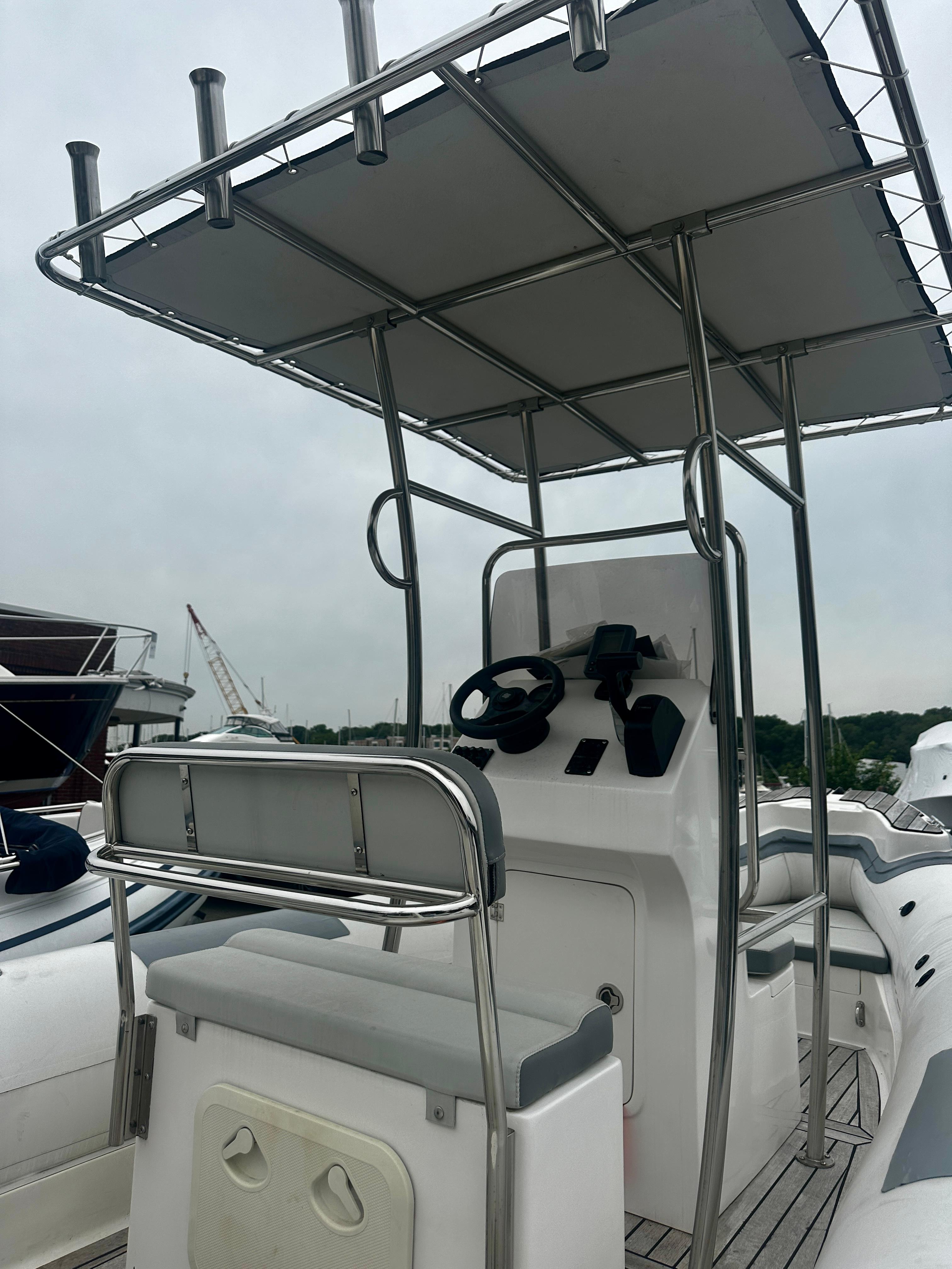 2021 Hedia Rib580 boat with steering console and canopy, docked at marina.