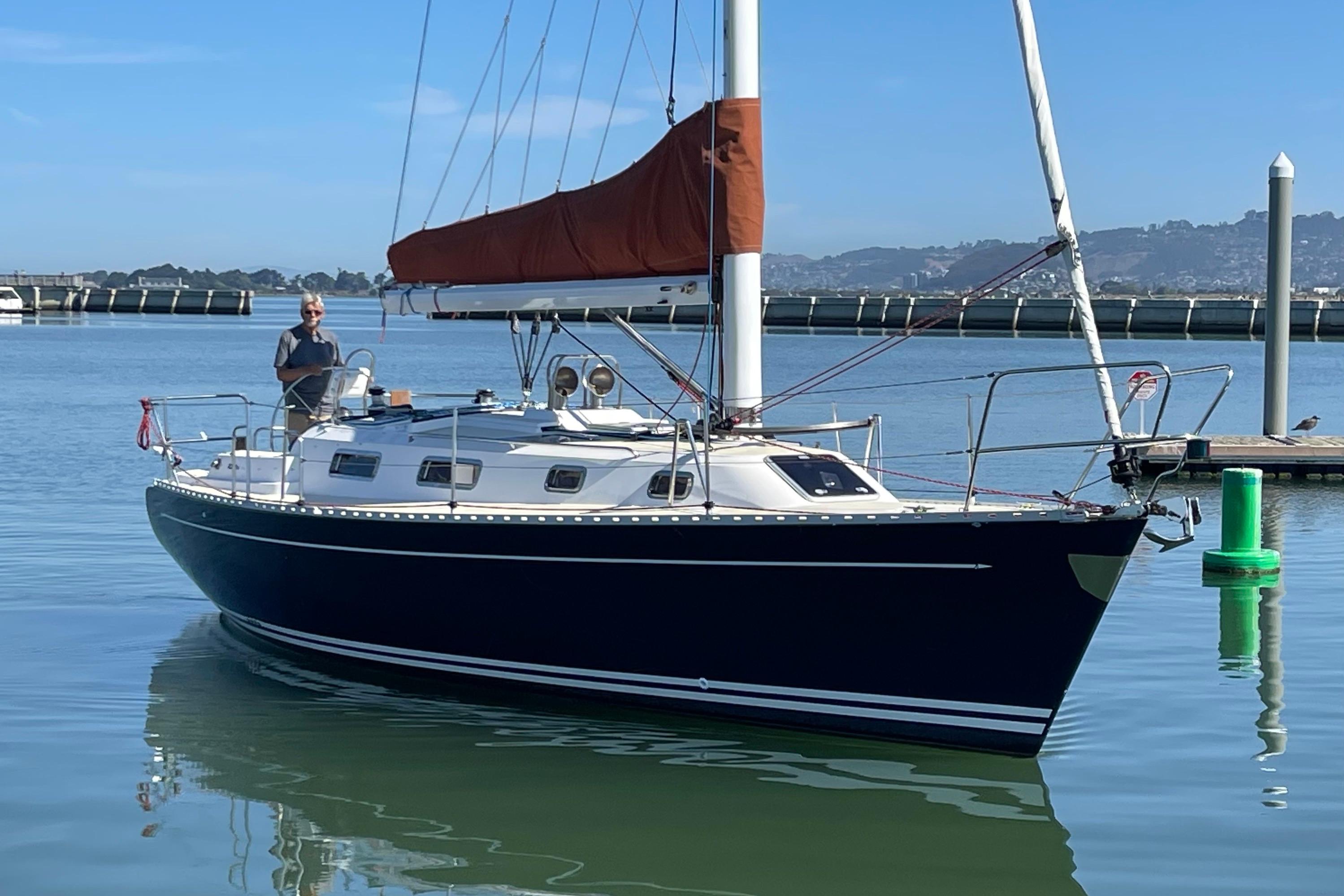 Sailboat Freedom 35, 1995 model, docked in calm waters with a person onboard.