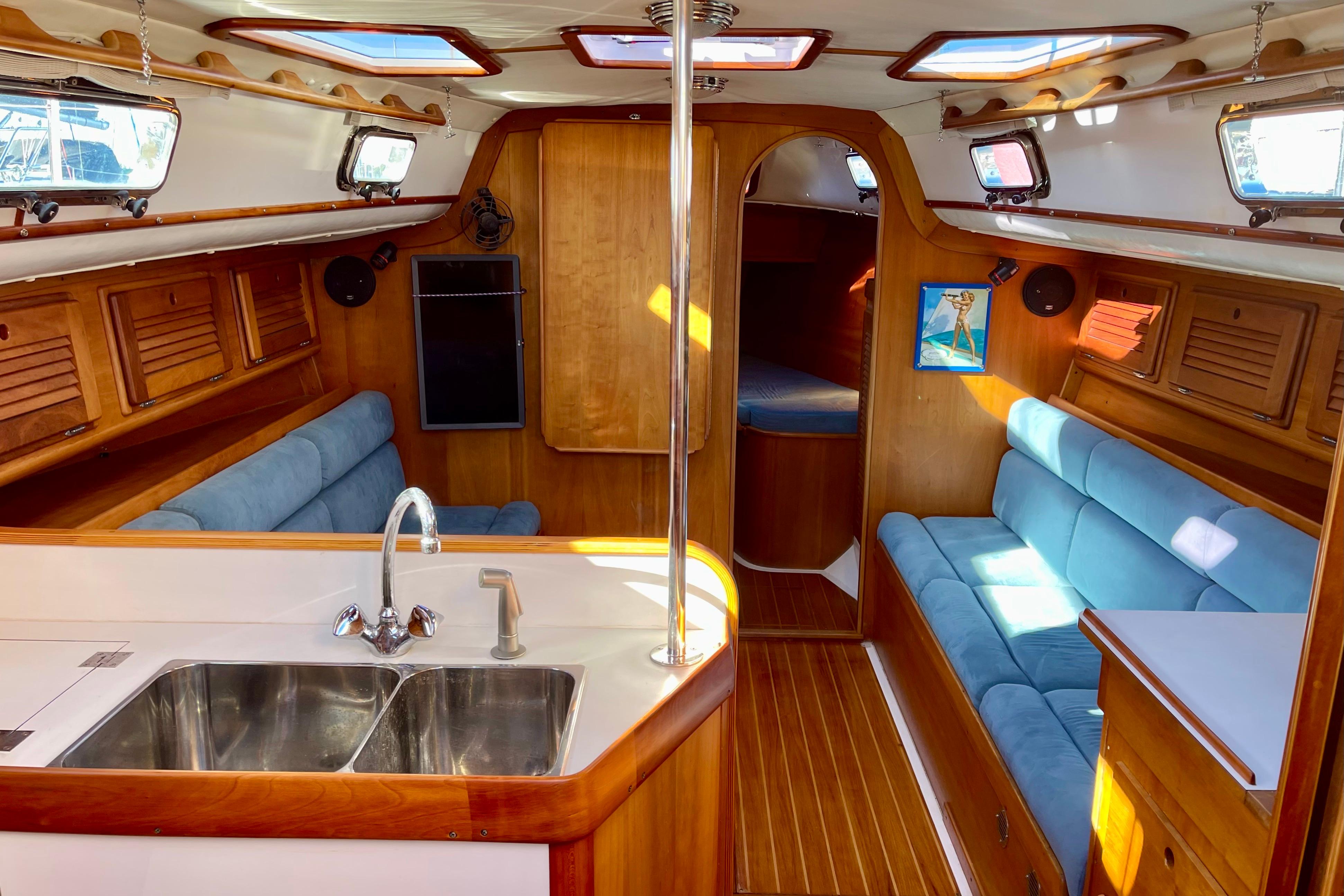 Interior of a 1995 Freedom 35 sailboat with wood finish and blue seating.