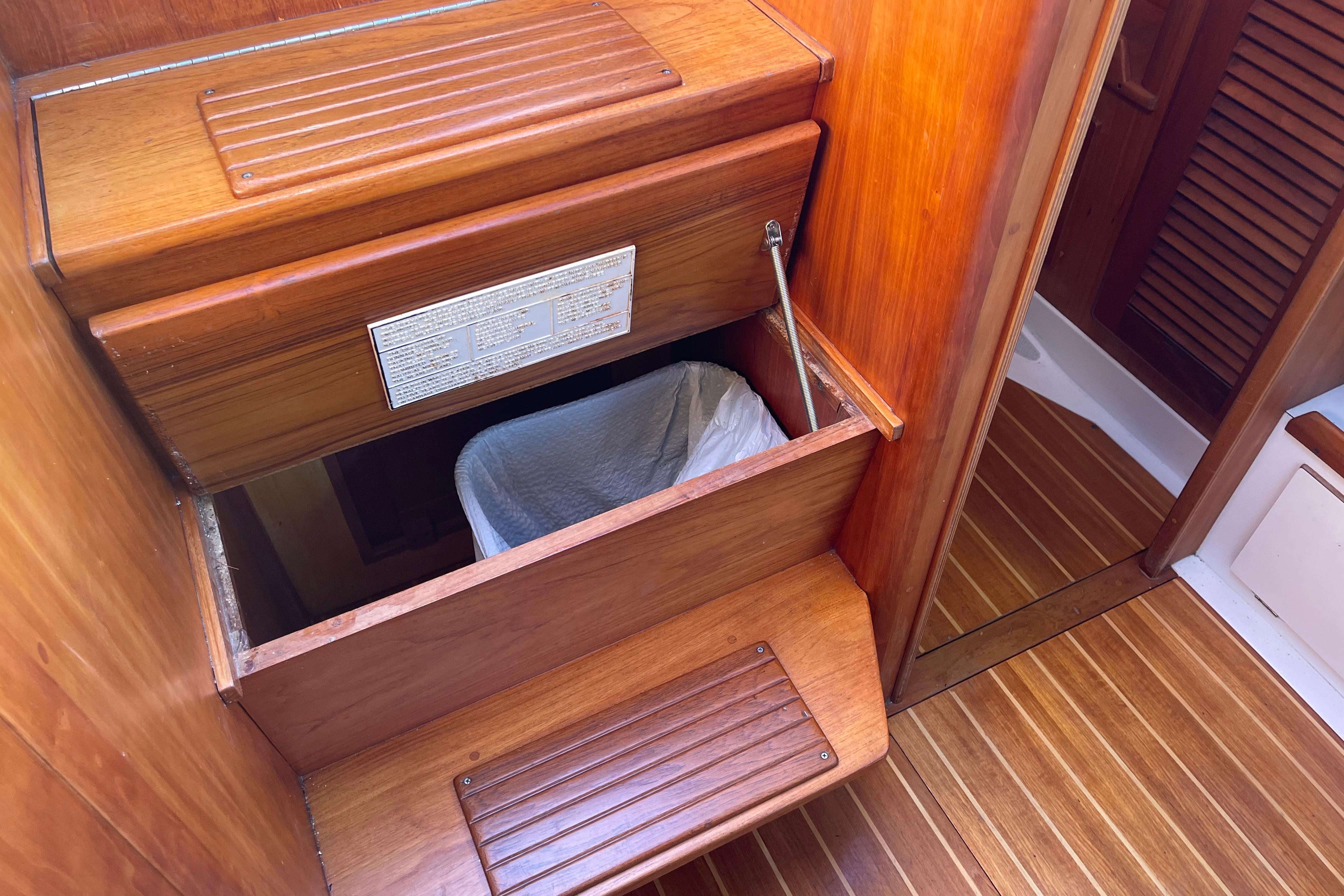 Wooden interior of a 1995 Freedom 35 boat with built-in storage compartment.