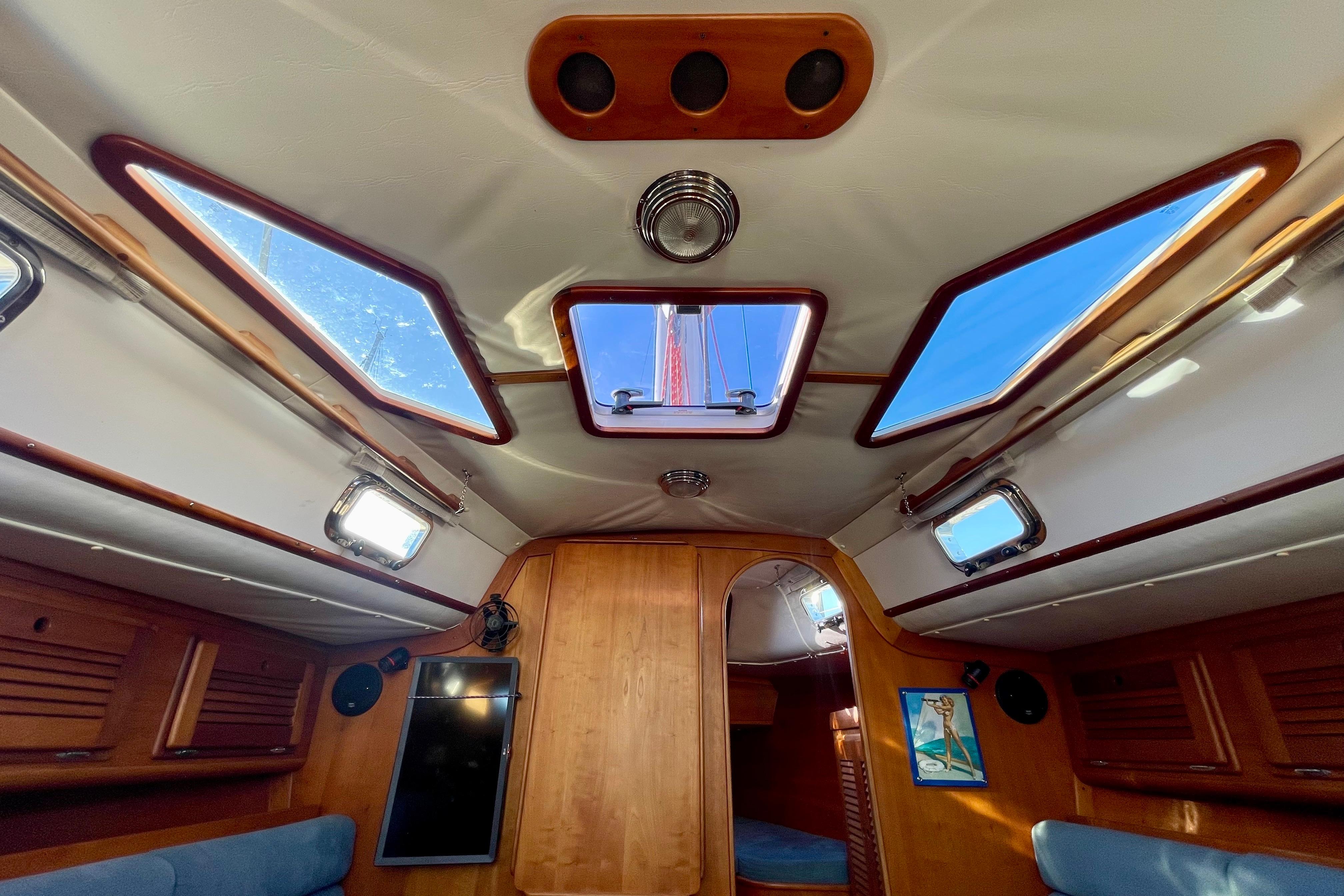 Interior view of a 1995 Freedom 35 sailboat, featuring skylights and wooden paneling.