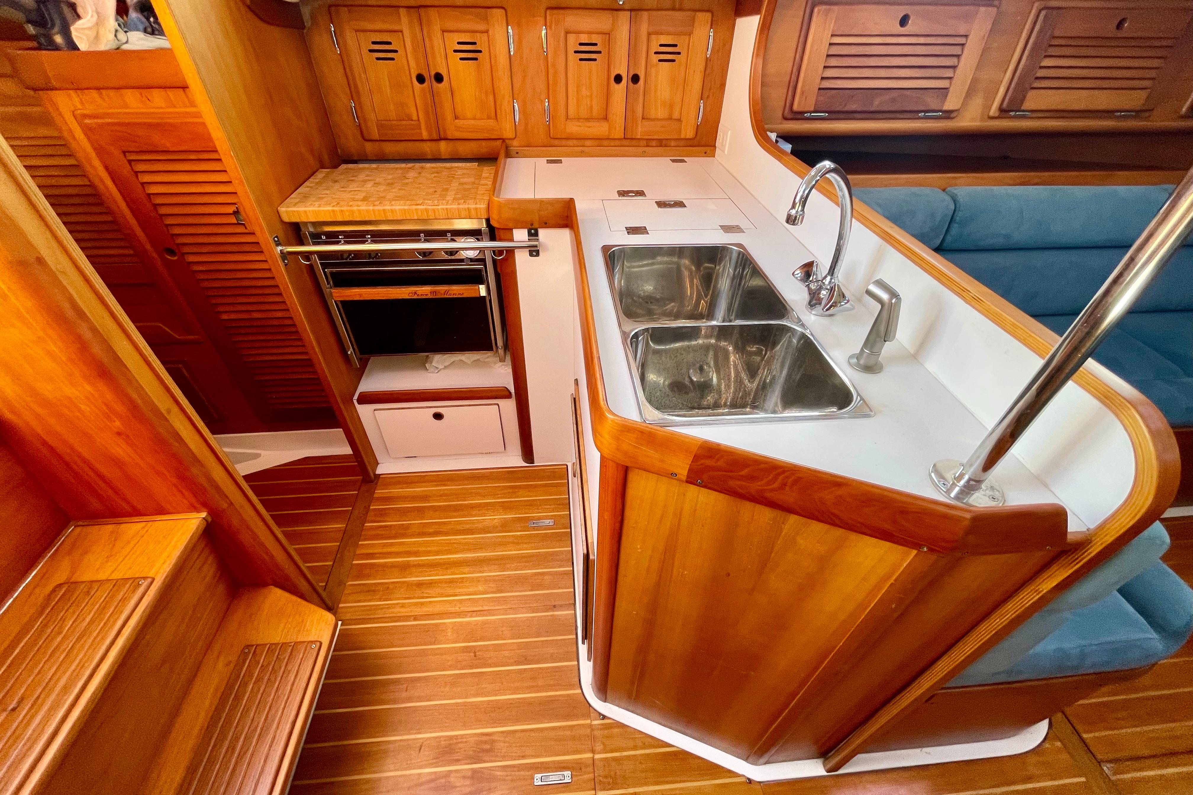 1995 Freedom 35 yacht interior with wooden cabinetry, dual sink, and compact kitchen area.