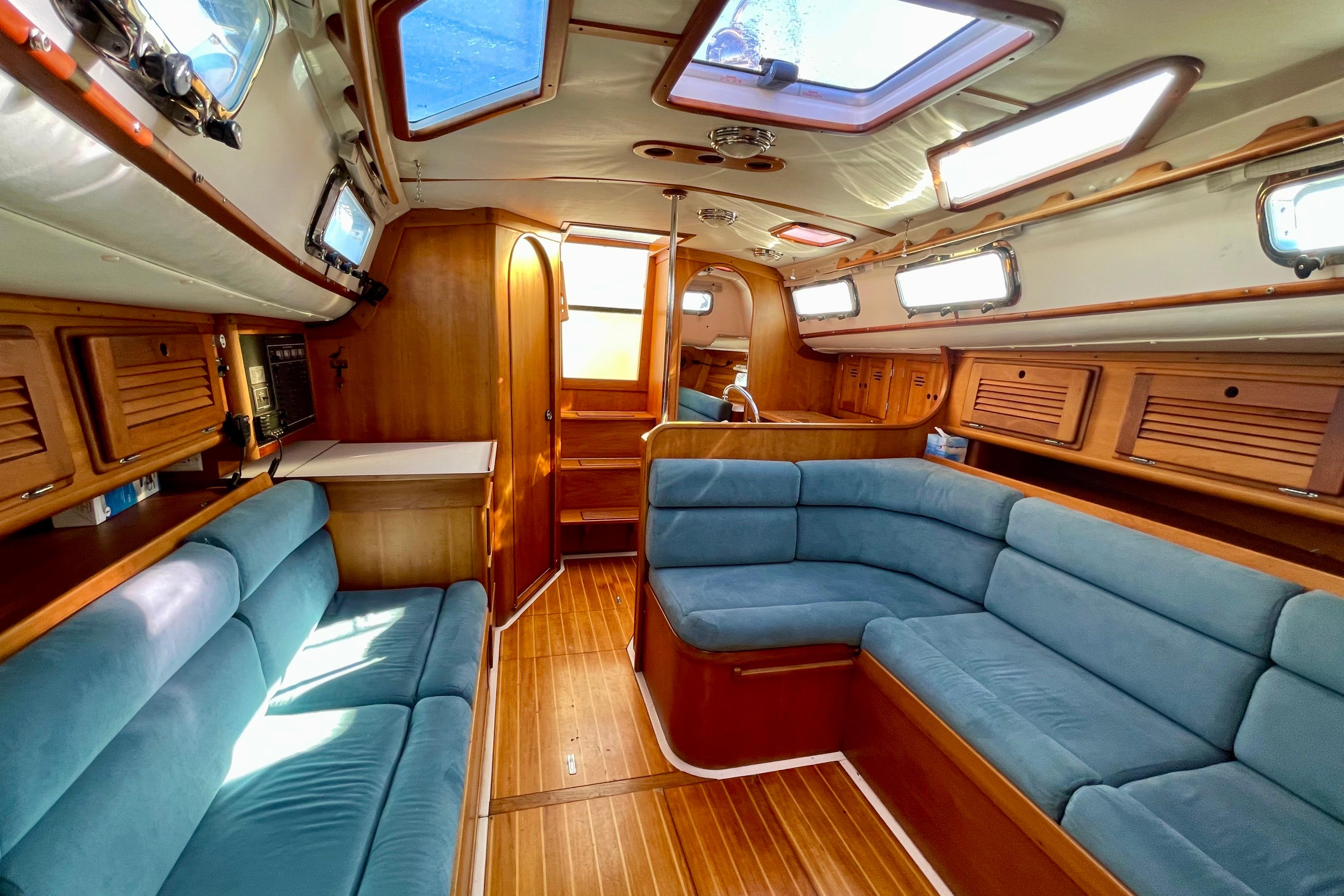 Interior of a 1995 Freedom 35 sailboat with blue seating and wooden finishes.