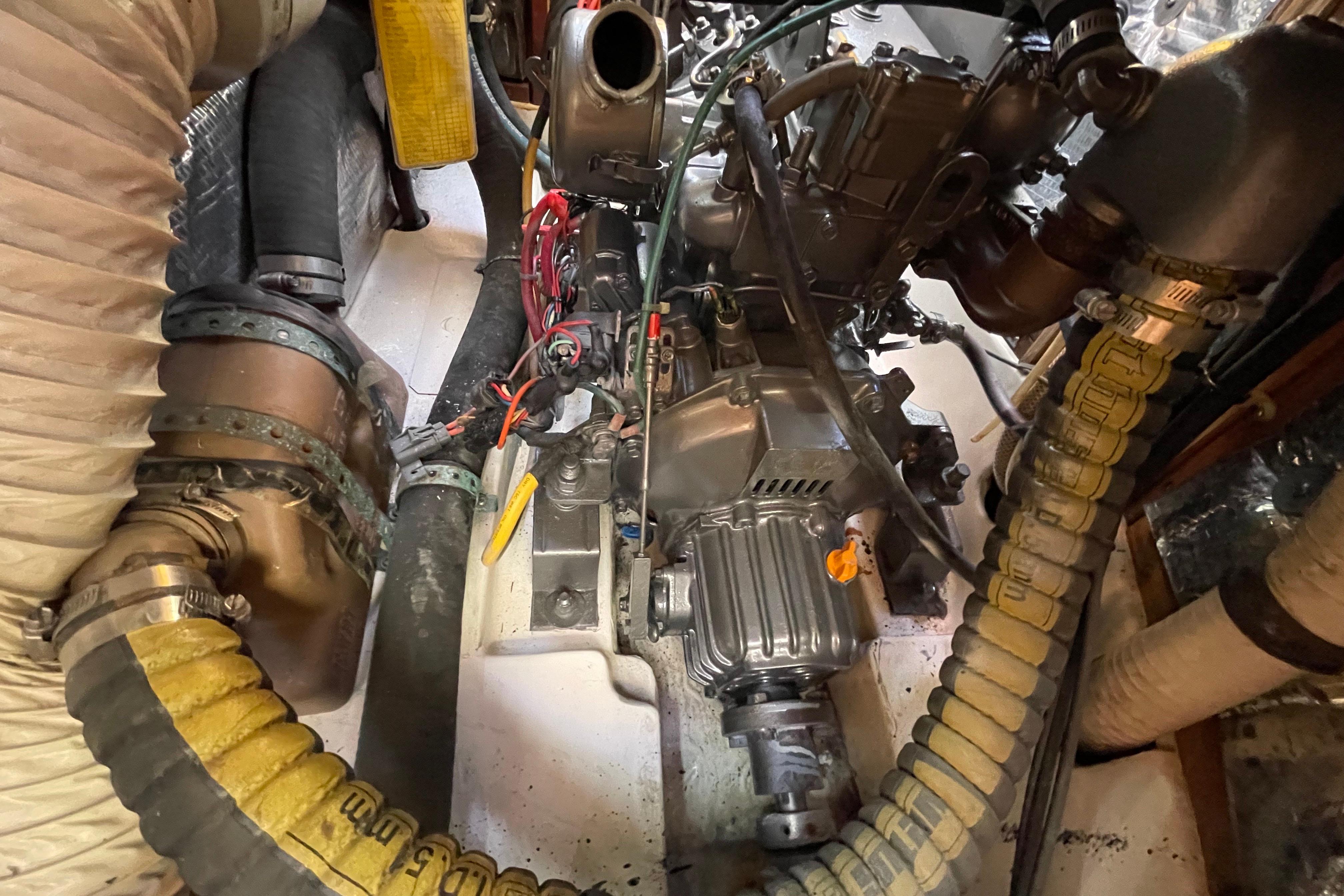 Engine compartment of a 1995 Freedom 35 sailboat, featuring hoses and mechanical components.