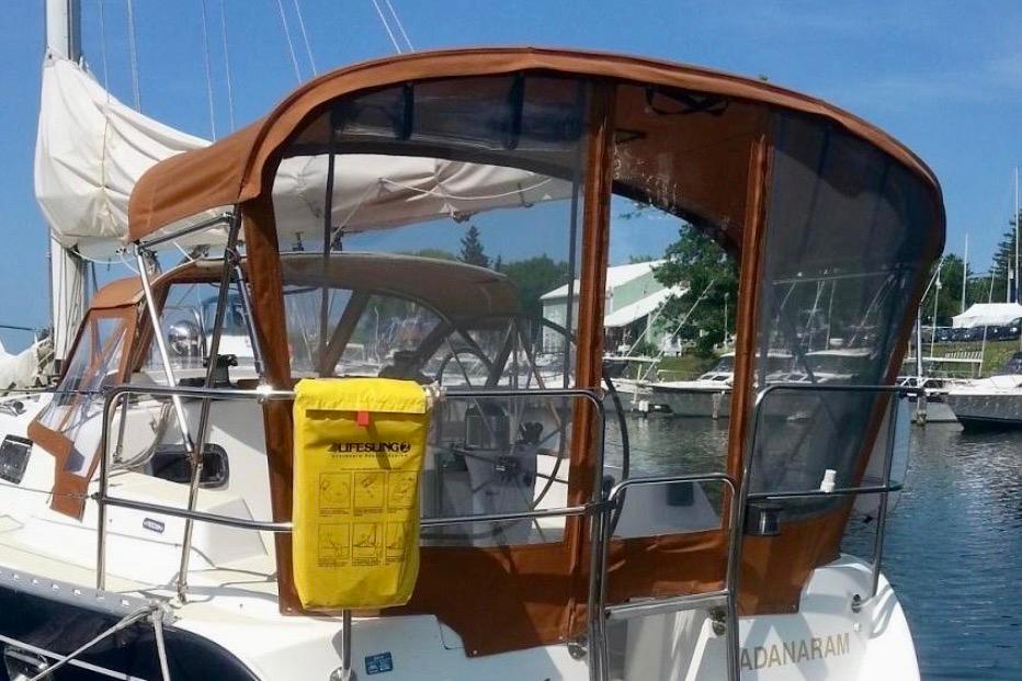 Sailboat Freedom 35, 1995 model, docked with brown canopy and visible lifesaving equipment.