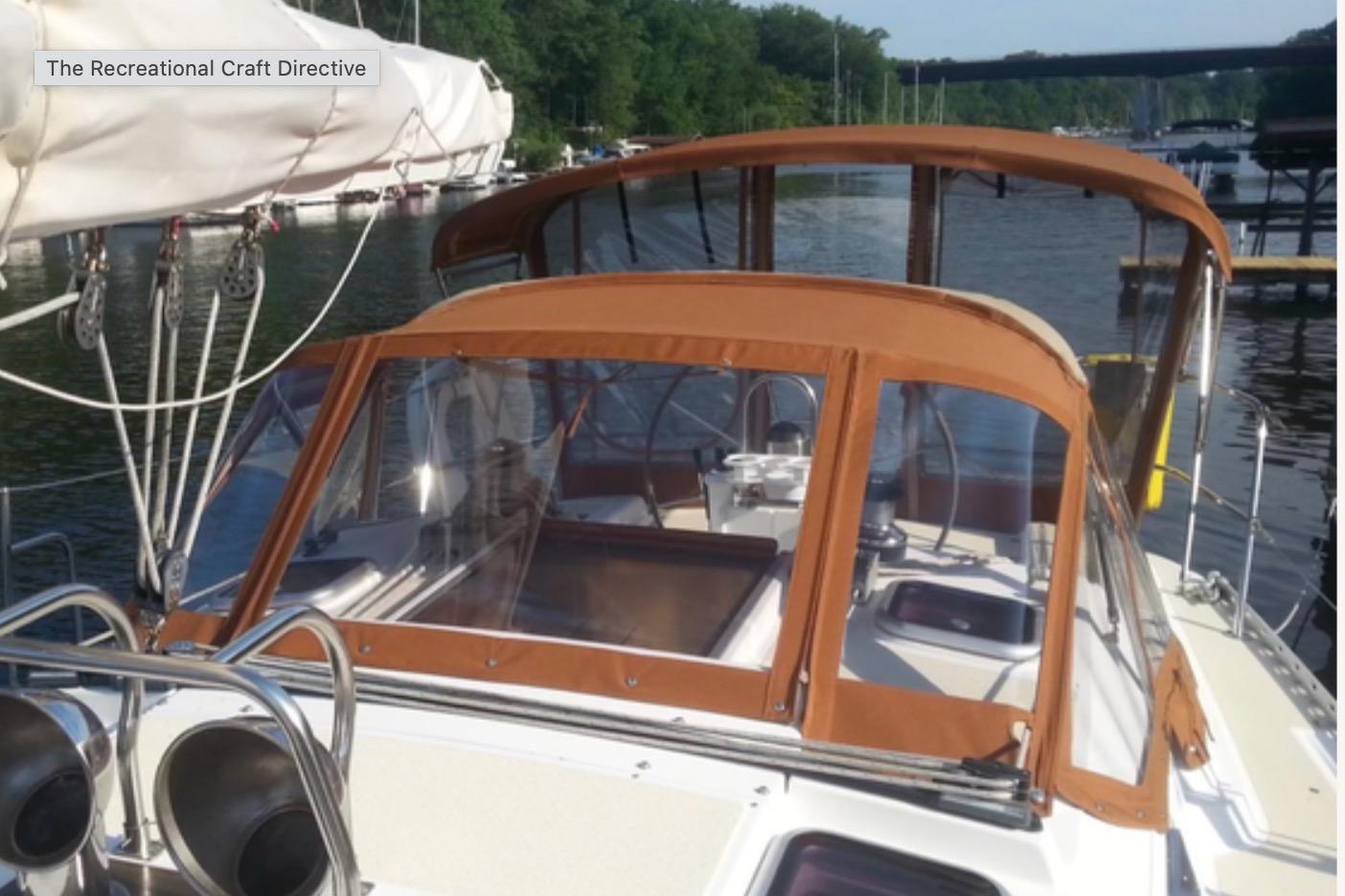 Sailboat Freedom 35, 1995 model, docked with brown canopy and clear windows.